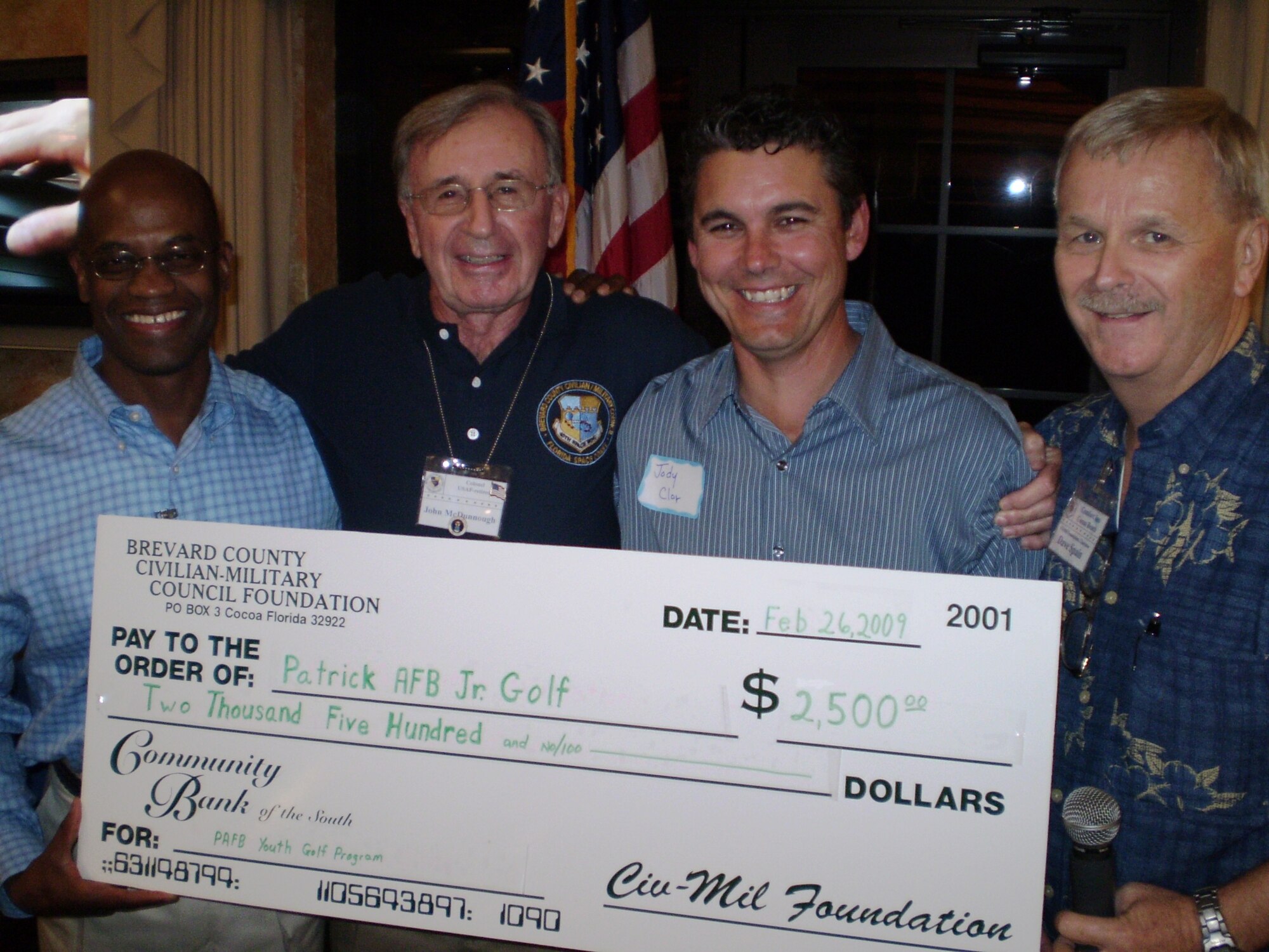 (From left to right) Brig. Gen. Edward L. Bolton, Jr., 45th Space Wing commander, Col. (ret.) John McDunnough, Junior Golf Volunteer and Brevard County Civilian-Military Council Foundation representative Jody Clor, director of the Manatee Cove Golf Course, and Dave Spain, also of the Brevard County Civilian-Military Council Foundation, are all enthusiastic supporters of the Patrick AFB Jr. Golf Program. Here, Colonel McDunnough and Mr. Spain present a $2,500 donation to help support the Jr. Golf Program and to improve the experience for the youth golfers of the Patrick AFB community. (U.S. Air Force photo/Chris Kraus)
