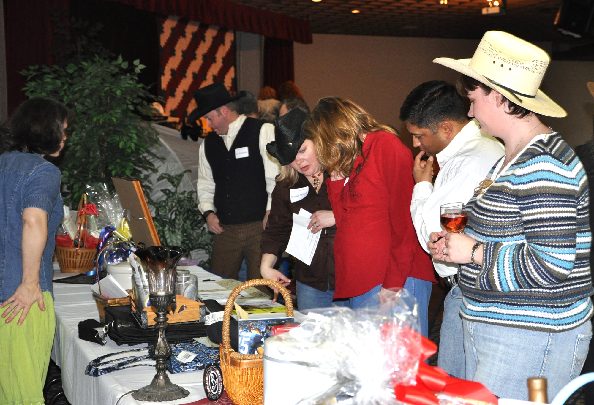 Participants at an Officers Spouses auction browse the tables full of items to be auctioned at Club Fairchild Mar. 6. Items auctioned off for the evening ranged from a complete set of camping gear to a luxurious spa getaway and an abundance of other items that were auctioned off for varying prices.  With various closing times on the auction tables, there was a frenzied rush seconds before closing for those ensuring they had bid the highest. (U.S. Air Force photo/Senior Airman Jocelyn Ford) Patty 