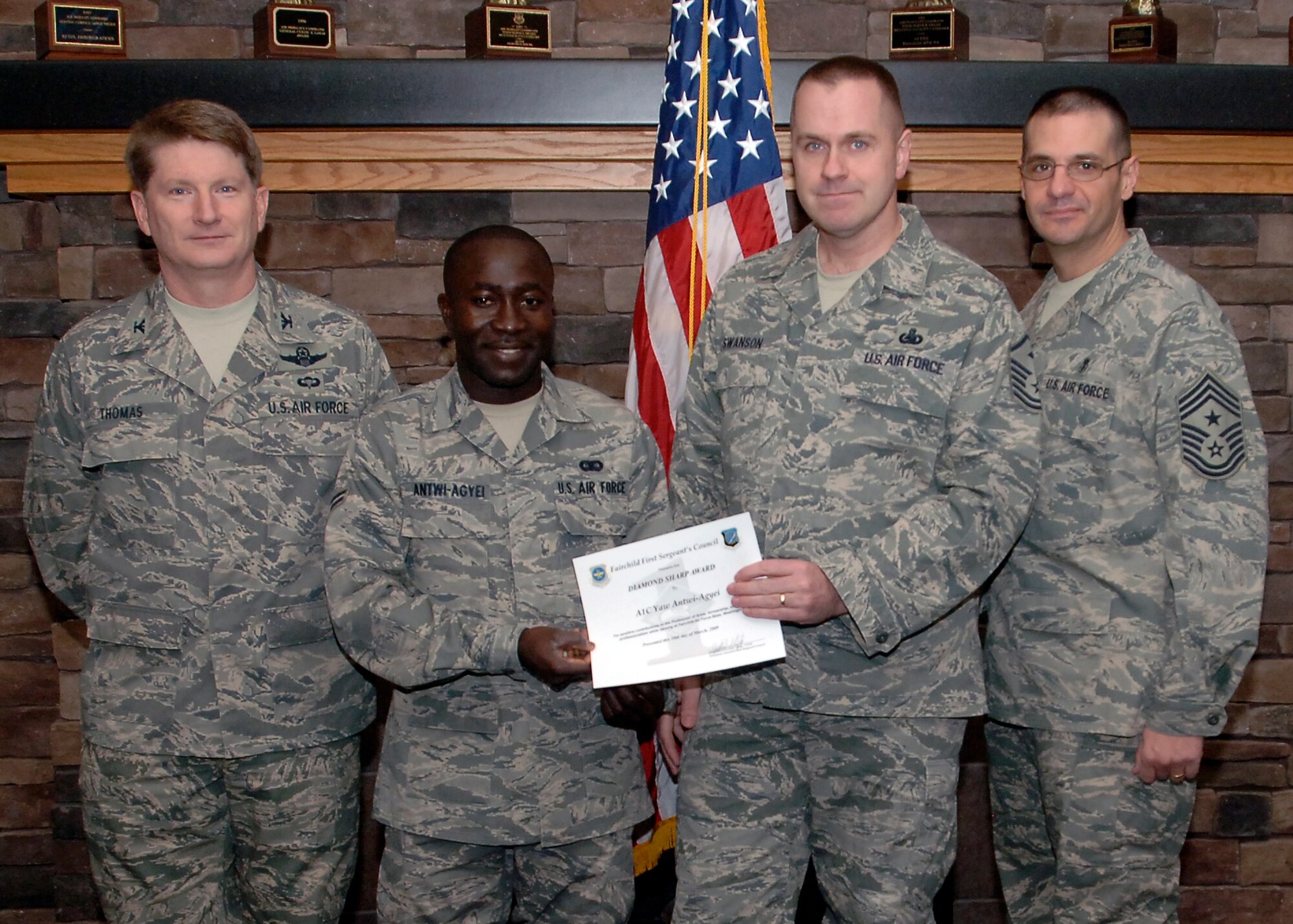 Col. Robert Thomas, 92nd Air Refueling Wing commander, and Chief Master Sgt. David Nordel, 92nd Air Refueling Wing command chief, present Airman 1st Class Yaw Antwi-Agyei, 92nd Communication Squadron knowledge operator, with the Diamond Sharp award during a breakfast at the Warrior Dining Facility on March 10. Airman Antwi-Agyei was nominated by Master Sgt. Robert Swanson, 92nd CS first sergeant, for his motivation to quickly excel in his career and his selflessness for volunteering to help fellow Airmen who are struggling with their fitness. (U.S. Air Force photo / Airman 1st Class Melissa L. Barnett)