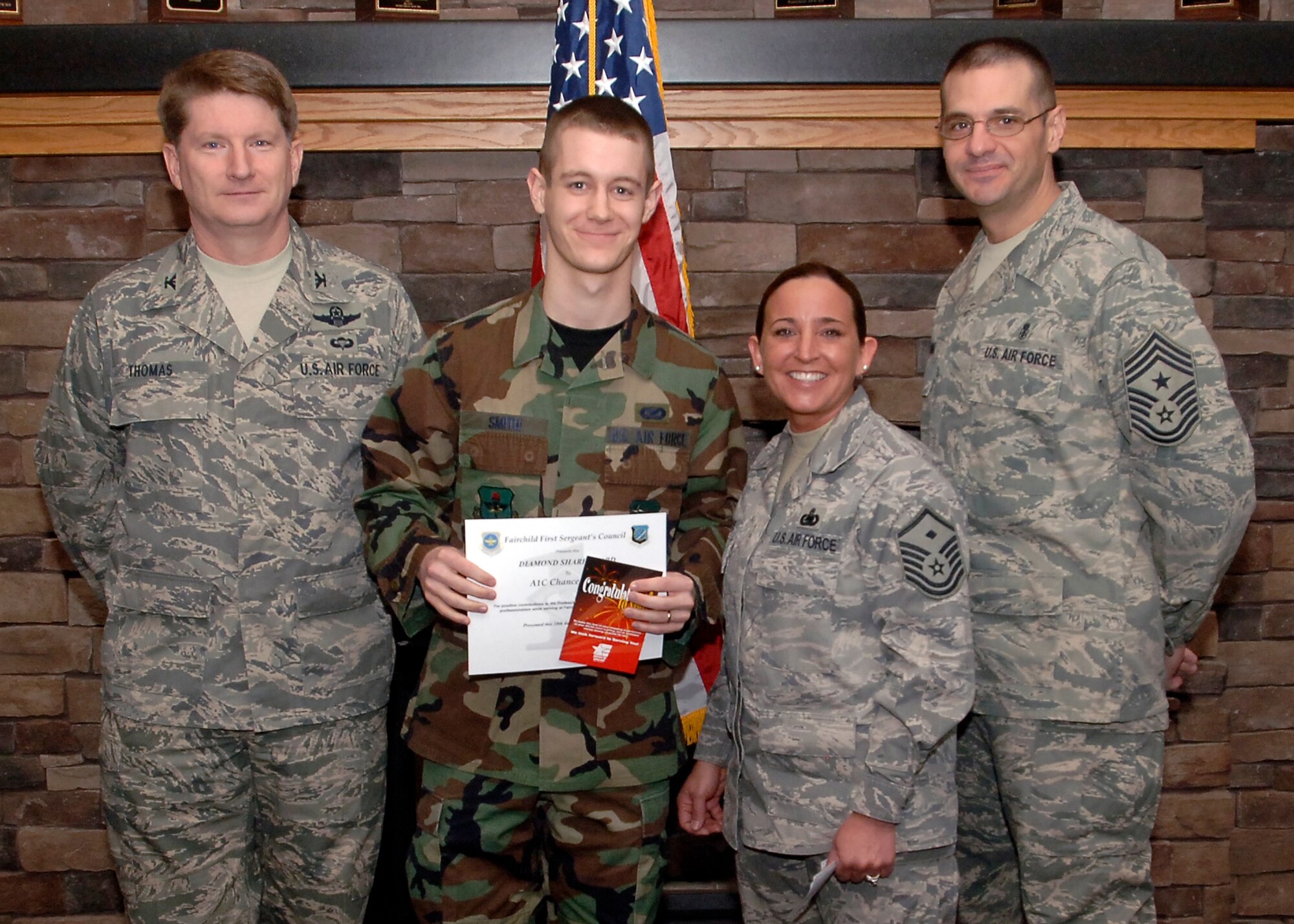 Col. Robert Thomas, 92nd Air Refueling Wing commander, and Chief Master Sgt. David Nordel, 92nd Air Refueling Wing command chief, award Airman 1st Class Chance Smith, 336th Training Squadron videographer, the Diamond Sharp award on March 10. Master Sgt. Carol Davis, 336th TRS first sergeant, nominated Airman Smith for his professionalism and self disciplined work ethic. (U.S. Air Force photo / Airman 1st Class Melissa L. Barnett)