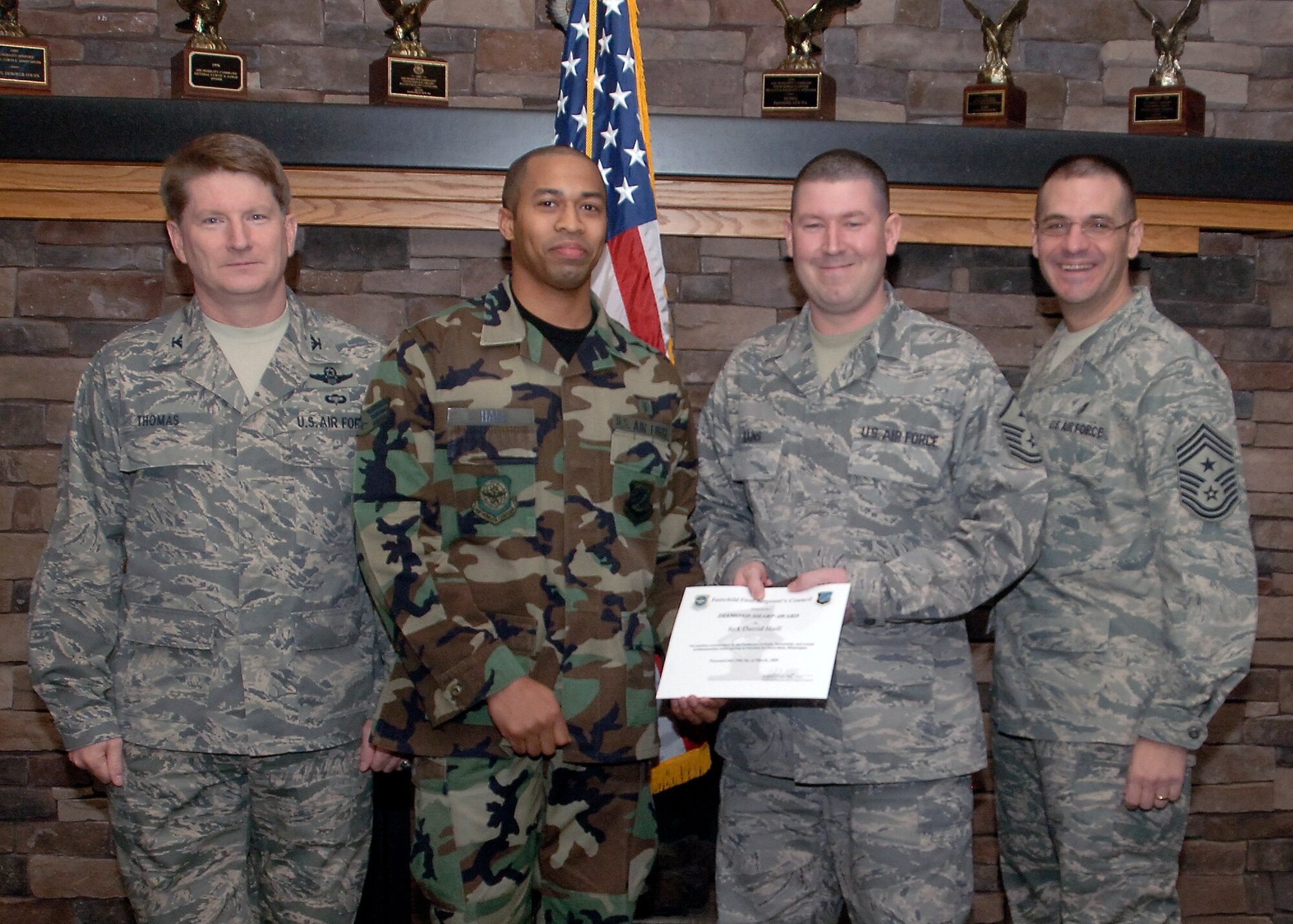 Master Sgt. Ken Rains, 92nd Medical Group, first sergeant, nominates Senior Airman David Hall, 92nd MDG aerospace medical technician, with the Diamond Sharp award during the Diamond Sharp Breakfast at the Warrior Dining Facility, March 10. Col. Robert Thomas, 92nd Air Refueling Wing commander, and  Chief Master Sgt. David Nordel, 92nd Air Refueling Wing command chief presented the award. (U.S. Air Force photo / Airman 1st Class Melissa L. Barnett)
