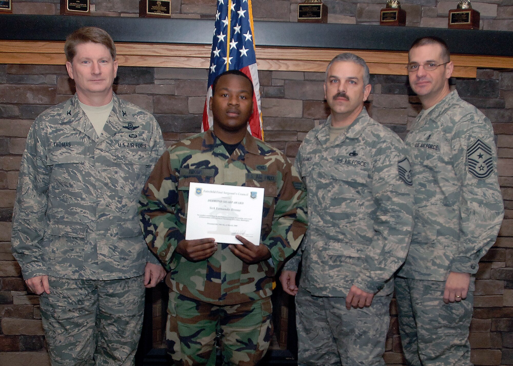 Col. Robert Thomas, 92nd Air Refueling Wing commander, and Chief Master Sgt. David Nordel, 92nd Air Refueling Wing command chief, present Senior Airman Fernando Brome, 92nd Mission Operation Support Squadron, with the Diamond Sharp Award at the Warrior Dinning Facility, March 10. Airman Brome was nominated by Master Sgt. Brian Lawrence, 92nd Mission Operation Support Squadron acting first sergeant, for his outstanding work performance and professionalism. (U.S. Air Force photo / Airman 1st Class Melissa L. Barnett)
