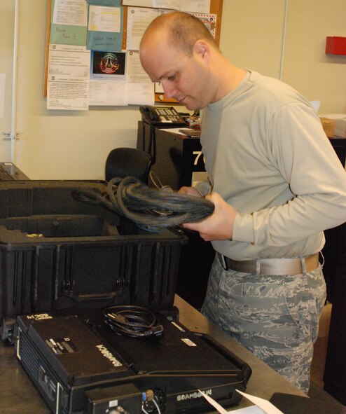Senior Airman Eric Haakenson, 12th Aircraft Maintenance Unit support specialist, inspects a vehicle test controller March 11 before it is checked back in. The VTC is a computer which monitors internal systems, provides fault indications and powers up the RQ-4 Global Hawk. (Photo by Airman 1st Class Chuck Broadway)