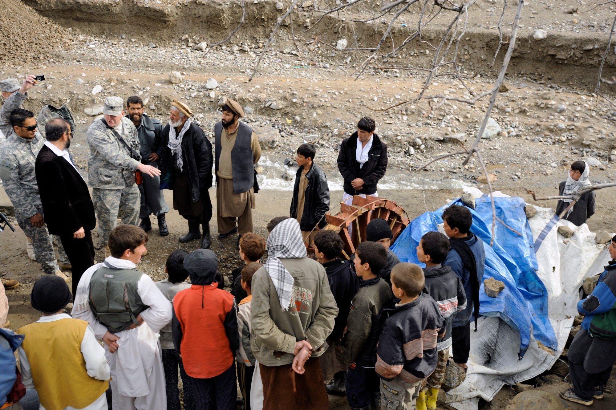 Lt. Col. Mark Stratton talks to villagers about a micro hydro pump provided by the Panjshir Provincial Reconstruction Team in Afghanistan March 4. The micro hydro uses water to create power for the village. Colonel Stratton is the Panjshir PRT commander. (U.S. Air Force photo/Staff Sgt. James L. Harper Jr.) 
