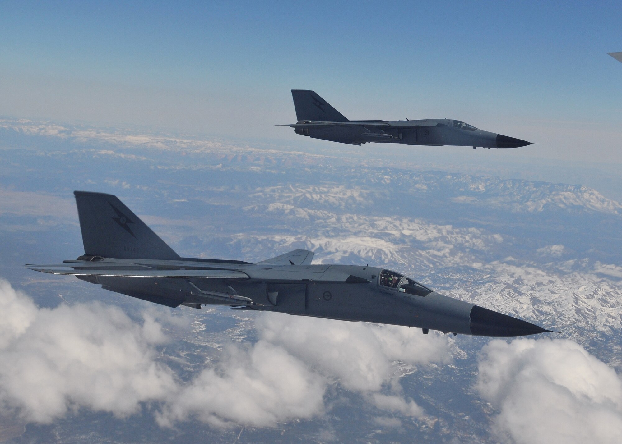 Royal Australian Air Force F-111C fighters formate on an Air Force KC-135R Stratotanker during a Red Flag 09-03 mission March 4.  The F-111Cs and their crews provided long-range strike capabilities for the exercise's "Blue" forces.  Many of the RAAF F-111s at Nellis Air Force Base, Nev., for Red Flag 09-03 are former U.S. Air Force aircraft that were based at Nellis in the 1960s.  Red Flag provides realistic combat training for U.S., allied and coalition air forces.  U.S. Air Force photo by Gary Emery  