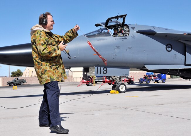Mr. Fred Whitehead, a contractor at the 414th Combat Training Squadron (Red Flag), pulls the pins before launching a Royal Australian Air Force F-111C during a  Red Flag exercise at Nellis Air Force Base, Nev., on Mar 11.  Mr. Whitehead was invited by the RAAF Red Flag team to launch this F-111, tail number 113, which he worked on as a crew chief in 1978.  This F-111 also flew the last official combat mission of the war in Southeast Asia in 1973.  (U.S. Air Force photo by Gary Emery).