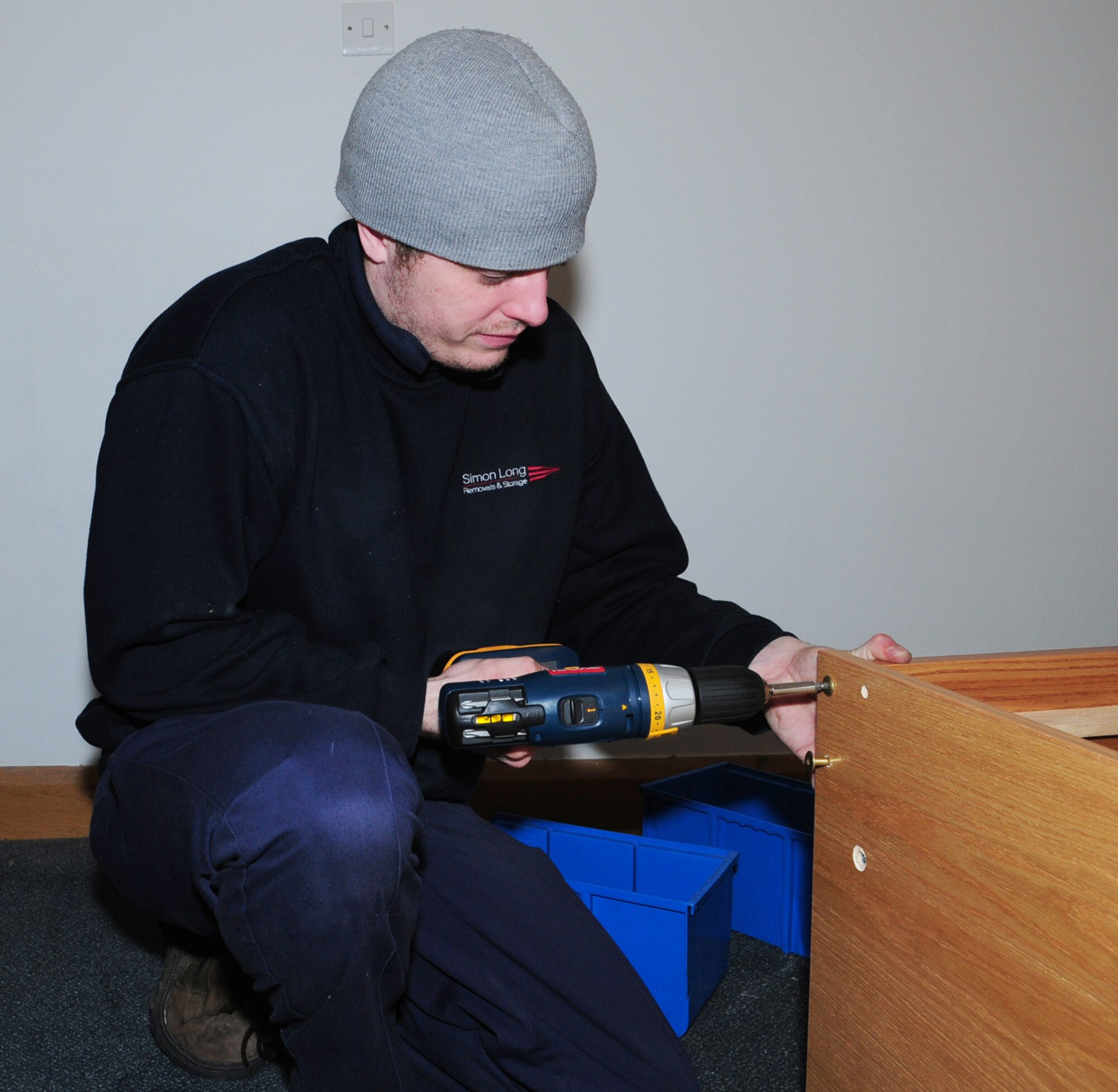Matt Hodges, a local contractor, screws together the side and end of a bed Feb. 25, 2009, in Dorm 210. The contractors deliverered and put together beds and other furniture in dormitories at RAFs Mildenhall and Lakenheath. (U.S. Air Force photo by Karen Abeyasekere)