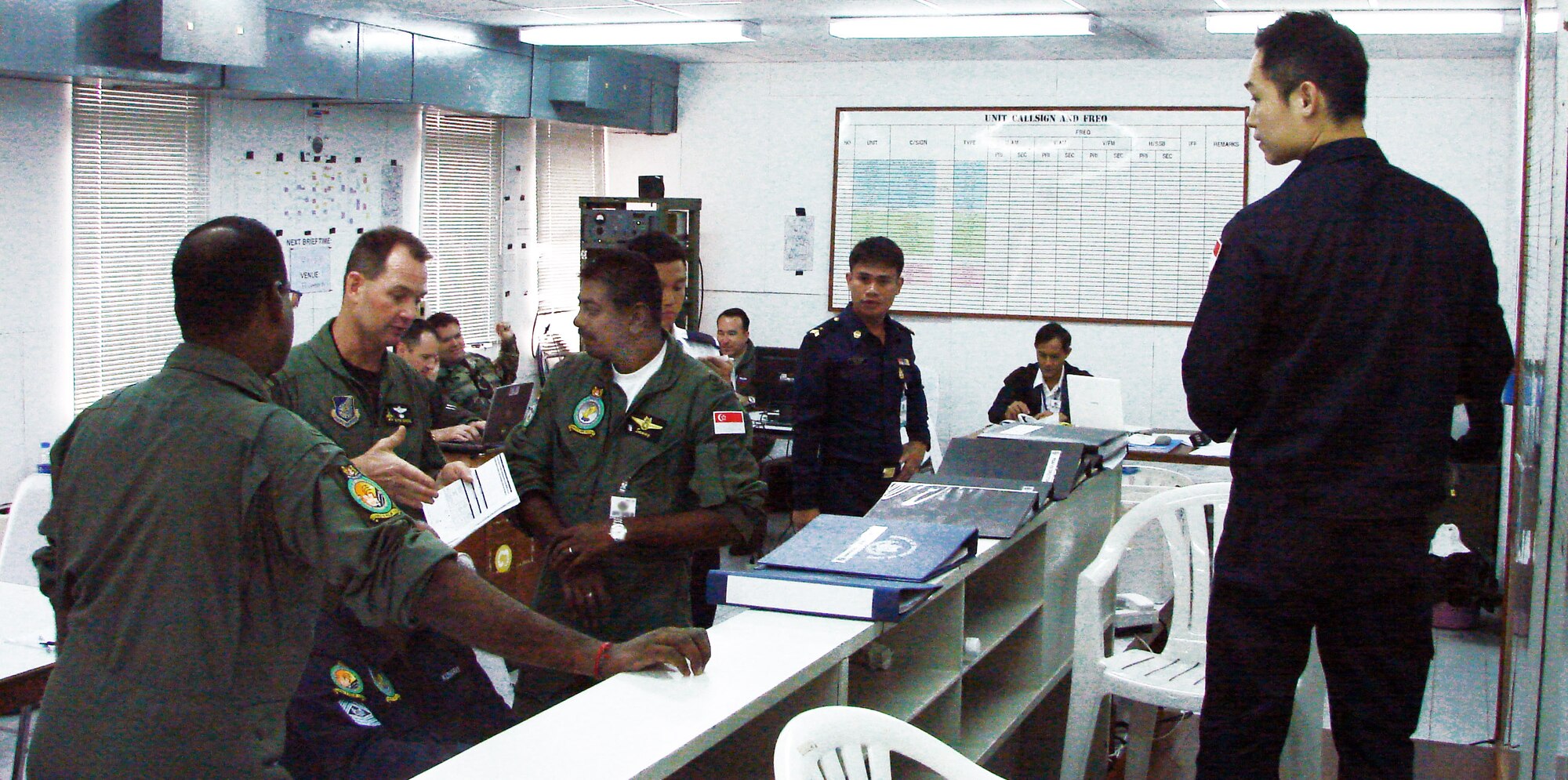 U.S. and Singapore air force personnel discuss the flying schedule in the Cope Tiger 2009 live fly cell March 11 at Korat Royal Thai air force base, Thailand. Cope Tiger is an annual, multilateral large force aerial exercise conducted in Thailand including U.S., Thai and Singaporean military forces. (U.S. Air Force photo/Capt. Erika Yepsen) 
