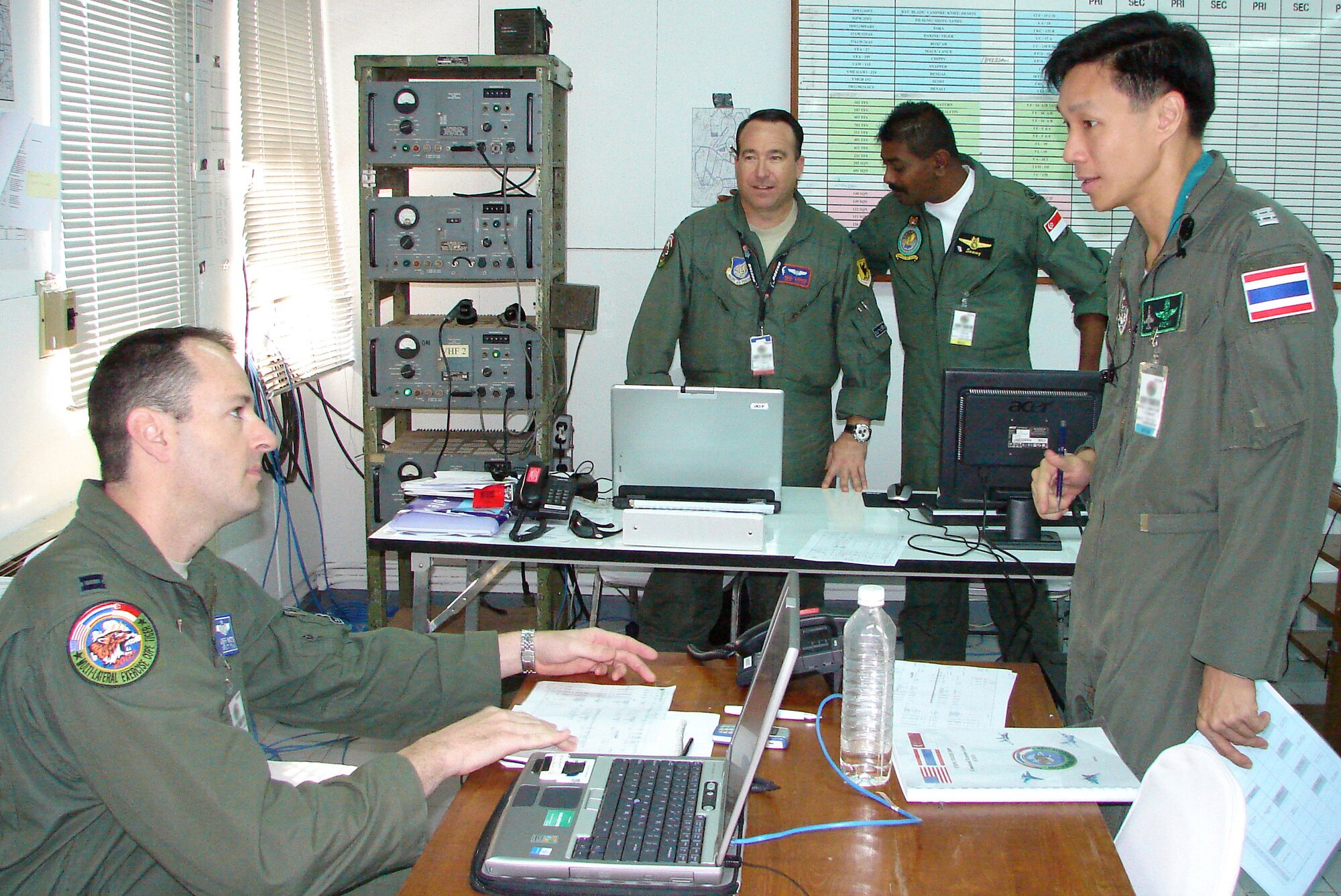 Capt. Jeff Watts (left to right), Capt. Paul Lankes, Singapore Warrant Officer Naranasamy Samyual and Royal Thai air force Wing Commander Arnon Charusombat discuss the Cope Tiger 2009 flying schedule in the live fly cell March 11 at Korat Royal Thai air force base, Thailand. Cope Tiger is an annual, multilateral large force aerial exercise conducted in Thailand including U.S., Thai and Singaporean military forces. (U.S. Air Force photo/Capt. Erika Yepsen) 
