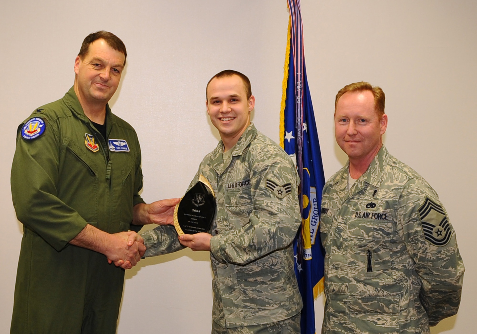 Airman 1st Class Zachary Elwood (center), 28th Medical Support Squadron biomedical equipment repair apprentice, receives the Air Combat Command Outstanding Biomedical Equipment Repair Airman of the Year Award from Col. Kory Cornum (left), ACC surgeon general, and Chief Master Sgt. John Murray, ACC medical enlisted force chief, March 3. The awards recognize Ellsworth healthcare providers in a range of specialties, ranks and accomplishments; many of whom spearheaded important programs, changes in their sections and volunteered their time to the local community. (U.S. Air Force photo/Senior Airman Kasey Zickmund)