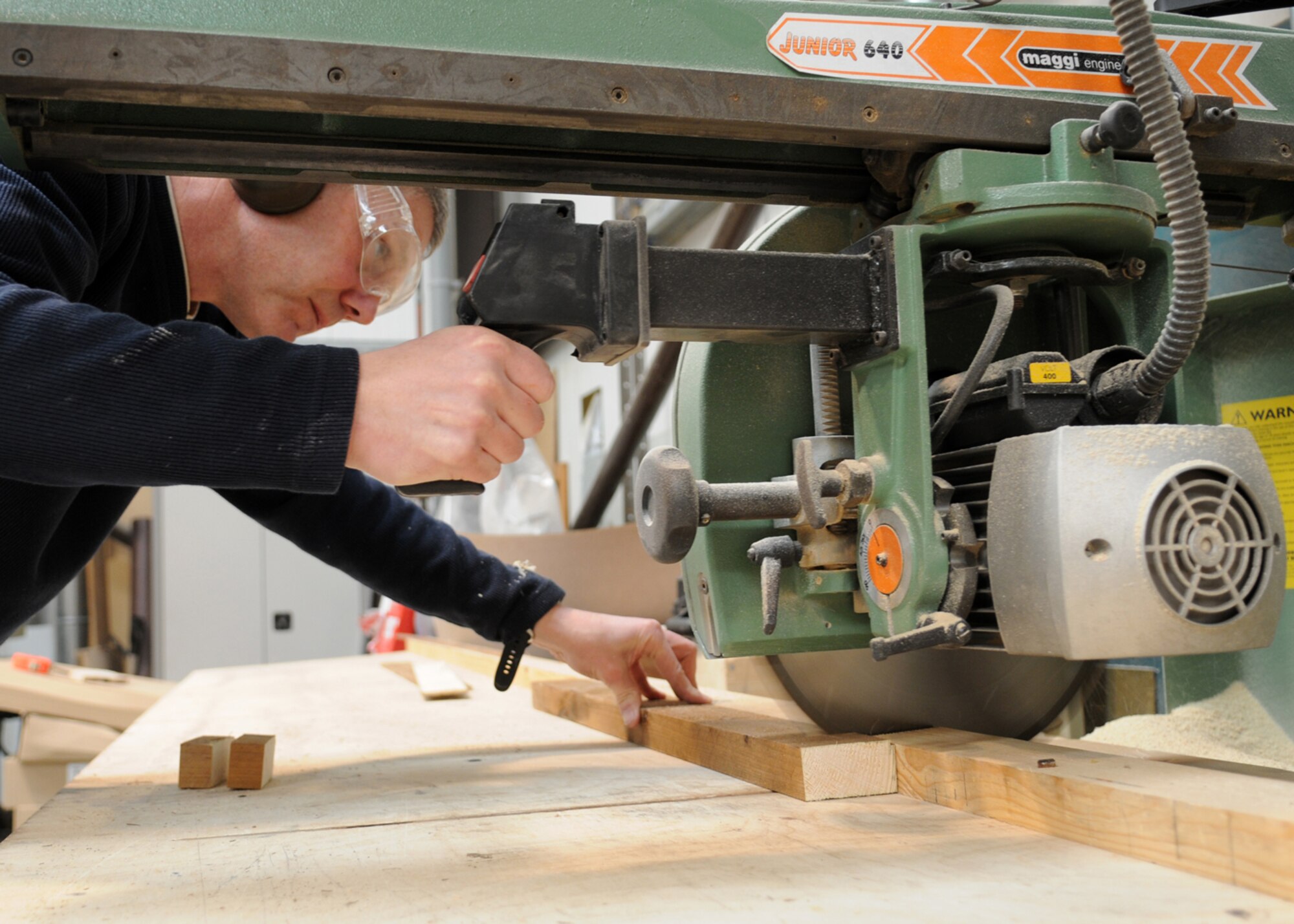 Ministry of Defence worker Philip Bower, 100th Civil Engineer Squadron maintenance carpenter, cuts wood to size with a cross cut saw as Mar 3, 2009, at RAF Mildenhall, England. Mr. Bower performs a wide variety of wood working services from refurbishing entire buildings to small window frame repairs (U.S. Air Force photo by Staff Sgt. Jerry Fleshman)
