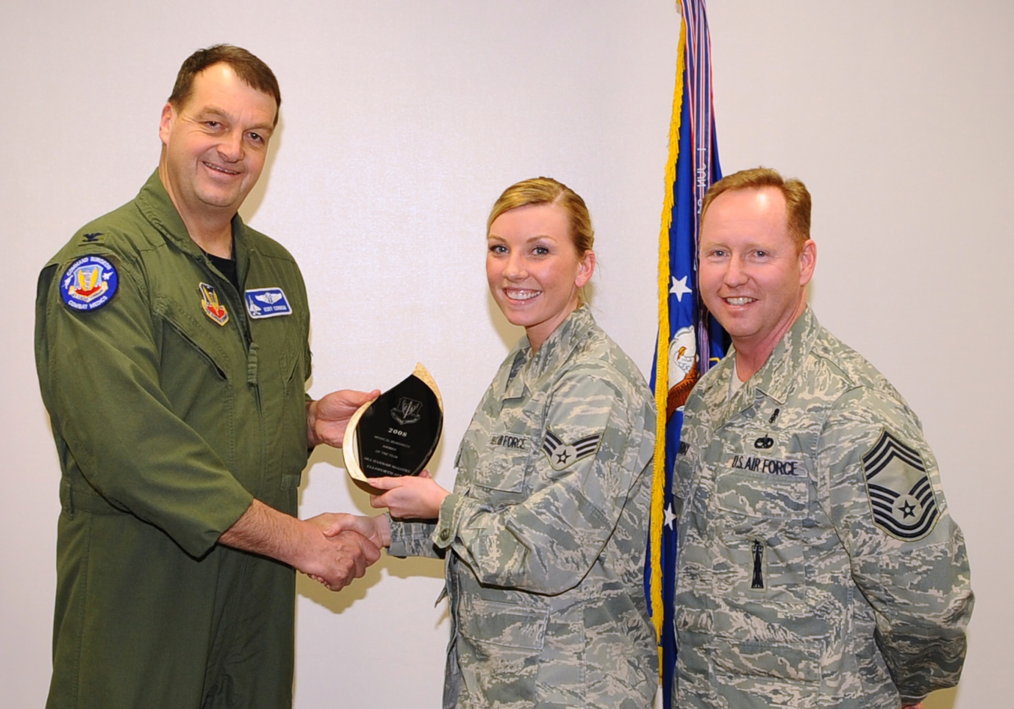 Senior Airman Hannah McGuire (center), 28th Medical Support Squadron health services management journeyman, receives the Air Combat Command Medical Readiness Airman of the Year Award from Col. Kory Cornum (left), ACC surgeon general, and Chief Master Sgt. John Murray, ACC medical enlisted force chief, March 3. The awards recognize Ellsworth healthcare providers in a range of specialties, ranks and accomplishments; many of whom spearheaded important programs, changes in their sections and volunteered their time to the local community. (U.S. Air Force photo/Senior Airman Kasey Zickmund)