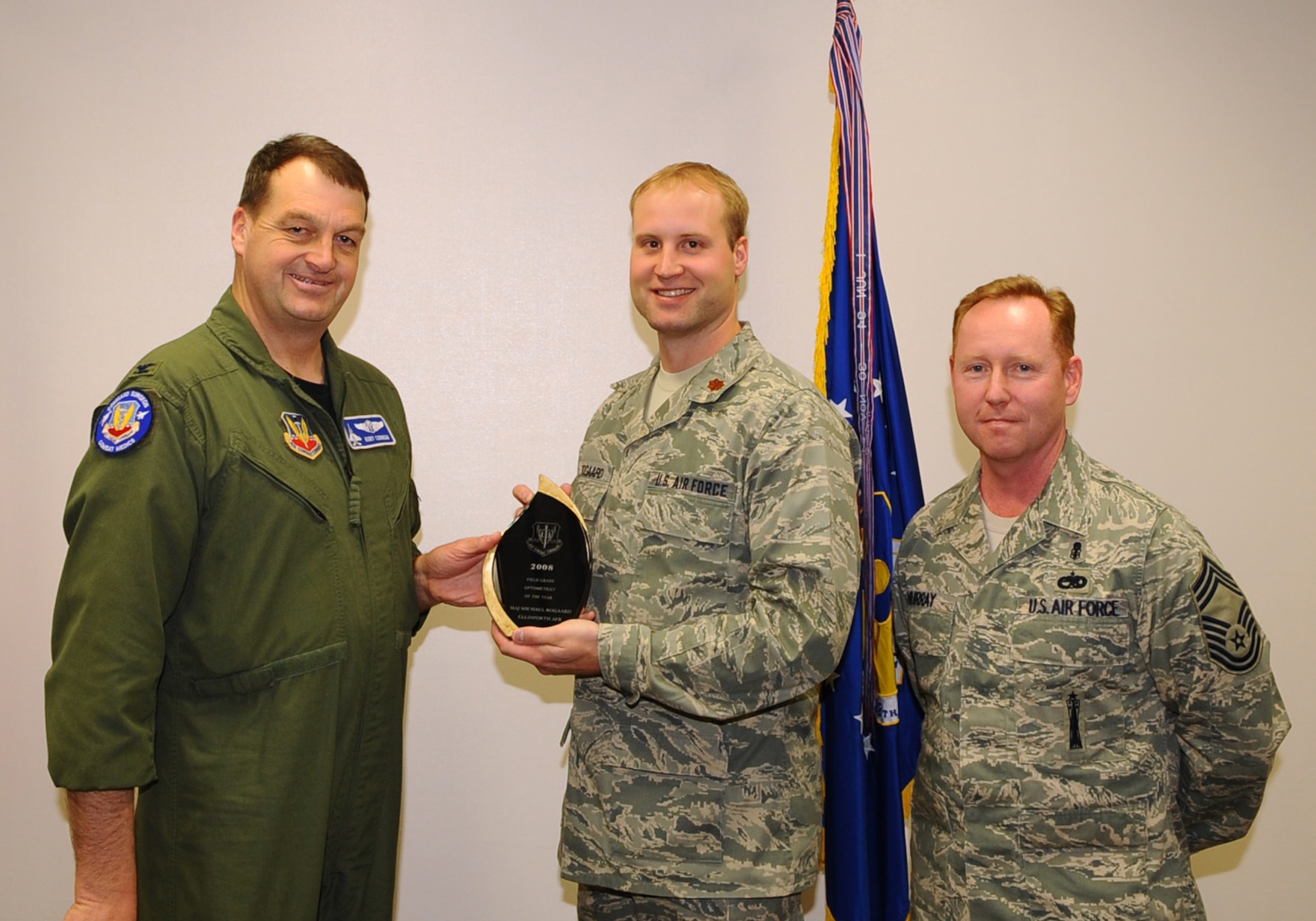 Maj. Michael Bogaard (center), 28th Medical Operations Squadron optometrist, receives the Air Combat Command Company Grade Optometrist of the Year Award from Col. Kory Cornum (left), ACC surgeon general, and Chief Master Sgt. John Murray (right), ACC medical enlisted force chief, March 3. The awards recognize Ellsworth healthcare providers in a range of specialties, ranks and accomplishments; many of whom spearheaded important programs, changes in their sections and volunteered their time to the local community. (U.S. Air Force photo/Senior Airman Kasey Zickmund)