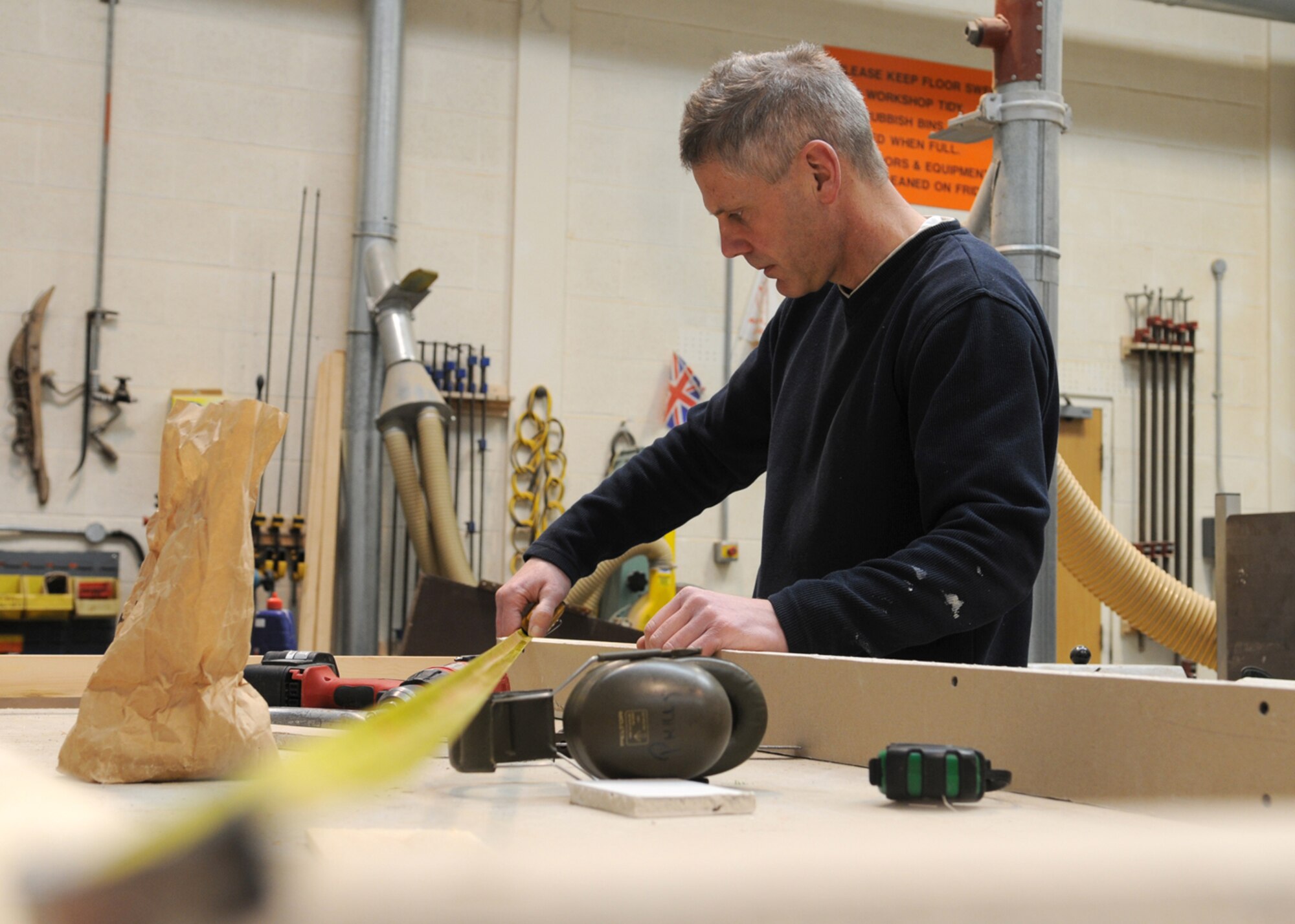 Ministry of Defence worker Mr. Philip Bower, a 100th Civil Engineer Squadron maintenance carpenter, measures the dimensions of a door frame March 3, 2009, at RAF Mildenhall, England. Mr. Bower measures all his work to exact specifications to ensure proper fit. (U.S. Air Force photo by Staff Sgt. Jerry Fleshman)
