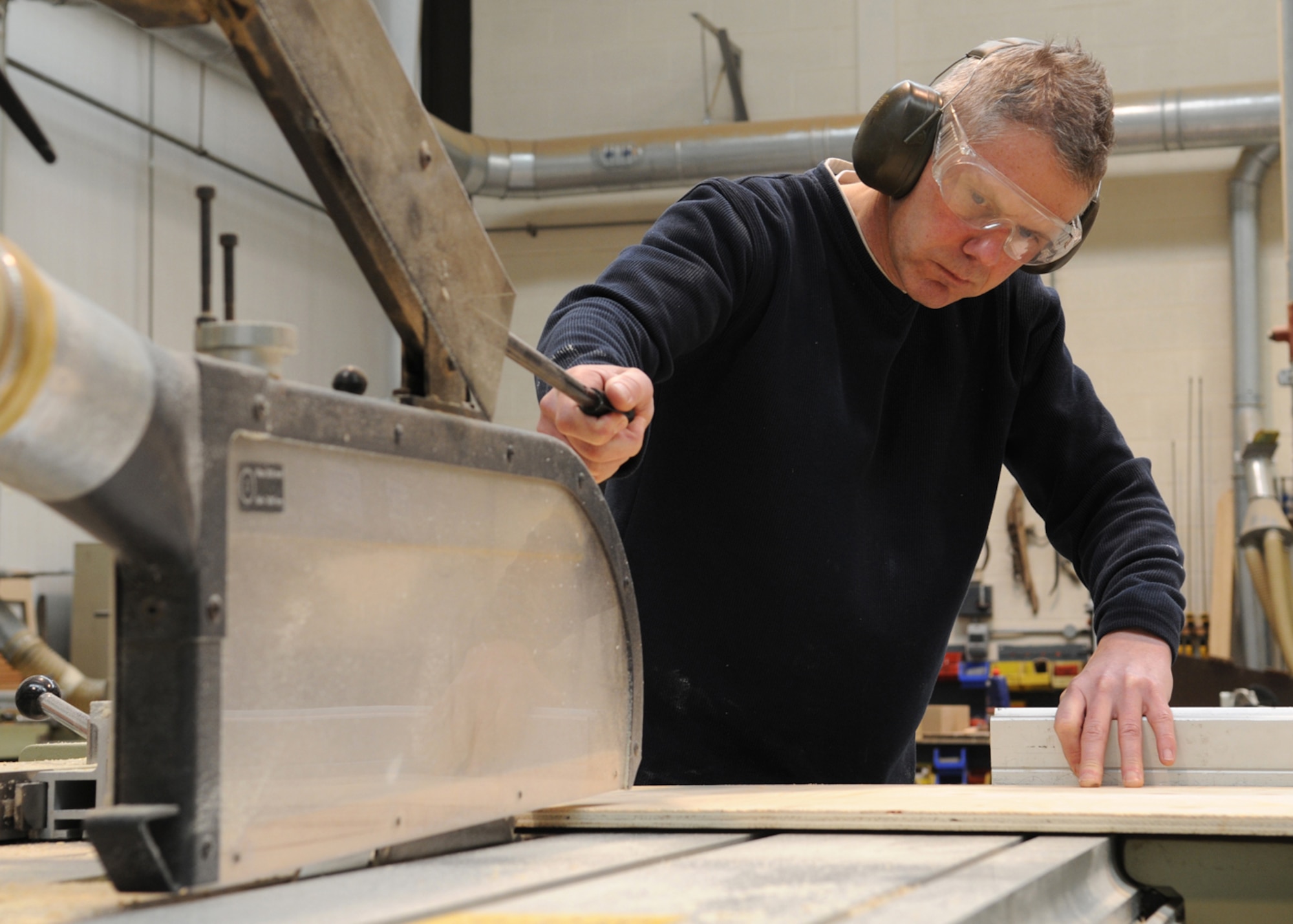 Ministry of Defence worker Philip Bower, a 100th Civil Engineering Squadron maintenance carpenter, cuts wood to size with a panel saw Mar 3, 2009, at RAF Mildenhall, England. Mr. Bower performs a wide variety of wood working services from refurbishing entire buildings to small window frame repairs (U.S. Air Force photo by Staff Sgt. Jerry Fleshman)