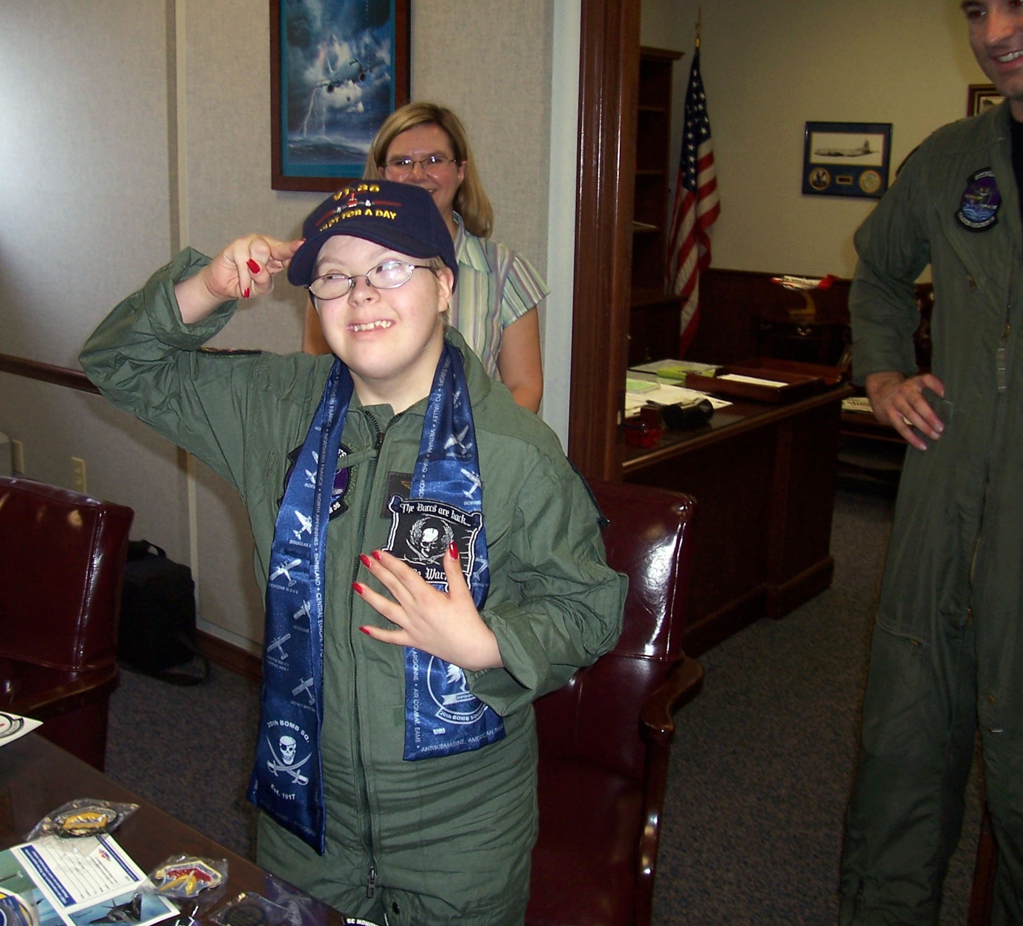 Pilot for a day, Sarahann Creech, returns a salute after receiving unit patches for her new flight suit Feb. 18. Sarahann spent the entire day seeing firsthand what aviators do. (Courtesy photo)