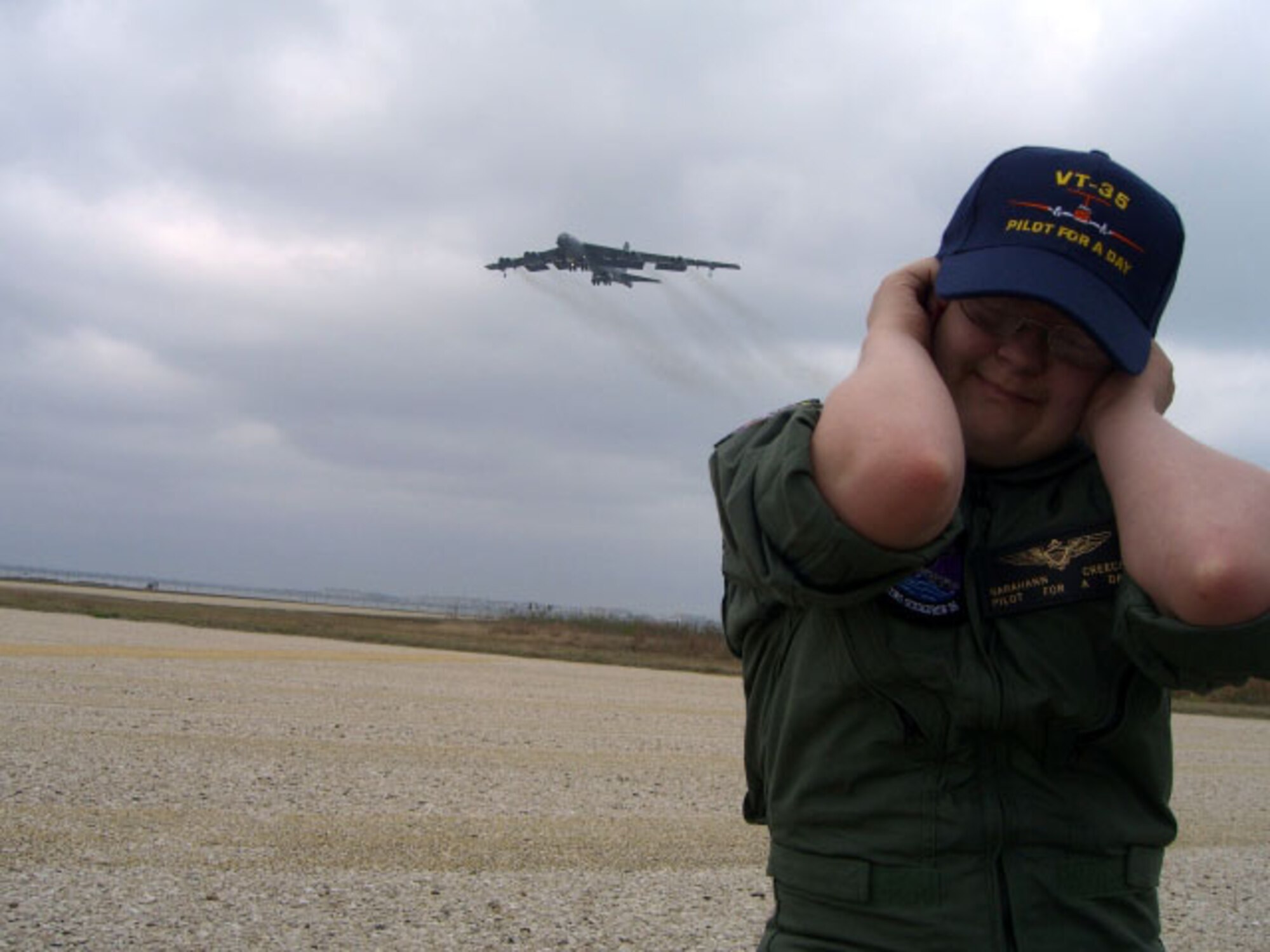 Pilot for a day, Sarahann Creech, 17, covers her ears as the B-52 flies over Feb. 18. Sarahann spent the entire day seeing firsthand what aviators do. (Courtesy photo)