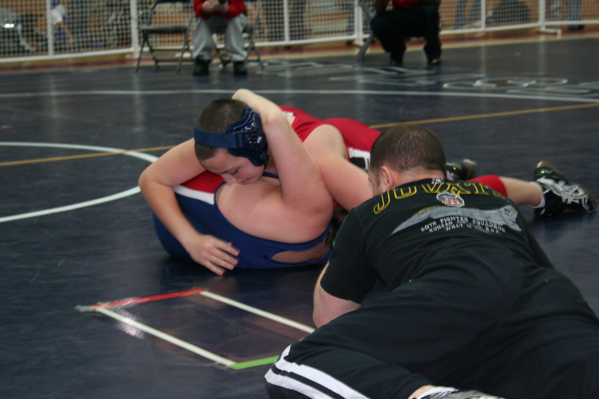 SPANGDAHLEM AIR BASE, Germany -- Capt. Dennis Lincoln, 52nd Operations Group, observes Xavier Flores working for the pin of Nicholas Ahlers during a wrestling match held at the Skelton Memorial Fitness Center March 7, 2009.  Children, ages 5-18, from schools throughout U.S. Air Forces Europe competed in the Spangdahlem Sabers Wrestling Tournament.  (Courtesy photo)  