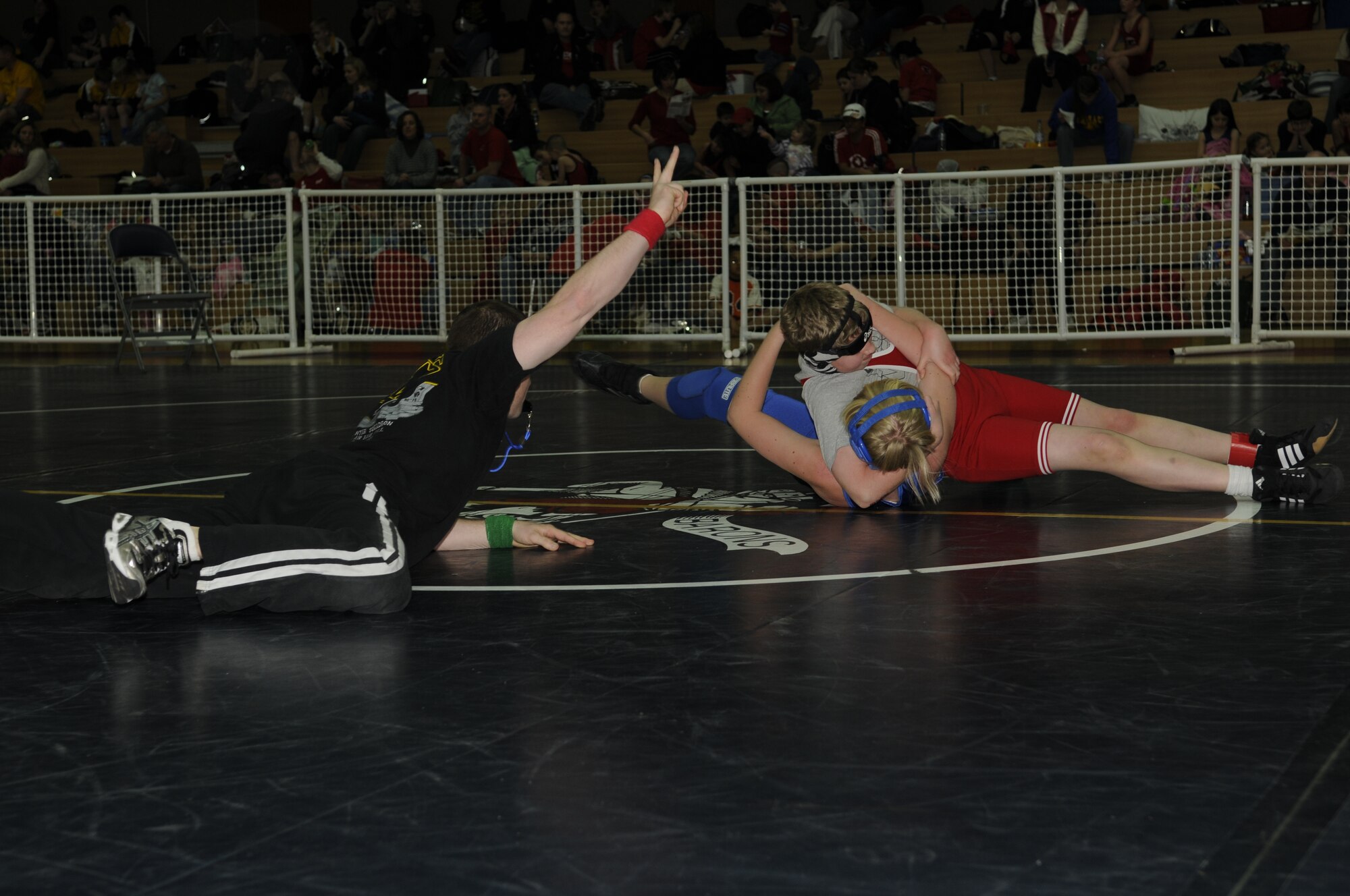 SPANGDAHLEM AIR BASE, Germany -- Capt. Dennis Lincoln, 52nd Operations Group, observes two competitors during a wrestling match held at the Skelton Memorial Fitness Center March 7, 2009.  Children, ages 5-18, from schools throughout U.S. Air Forces Europe competed in the Spangdahlem Sabers Wrestling Tournament.  (U.S. Air Force photo by Senior Airman Allen Pollard)  
