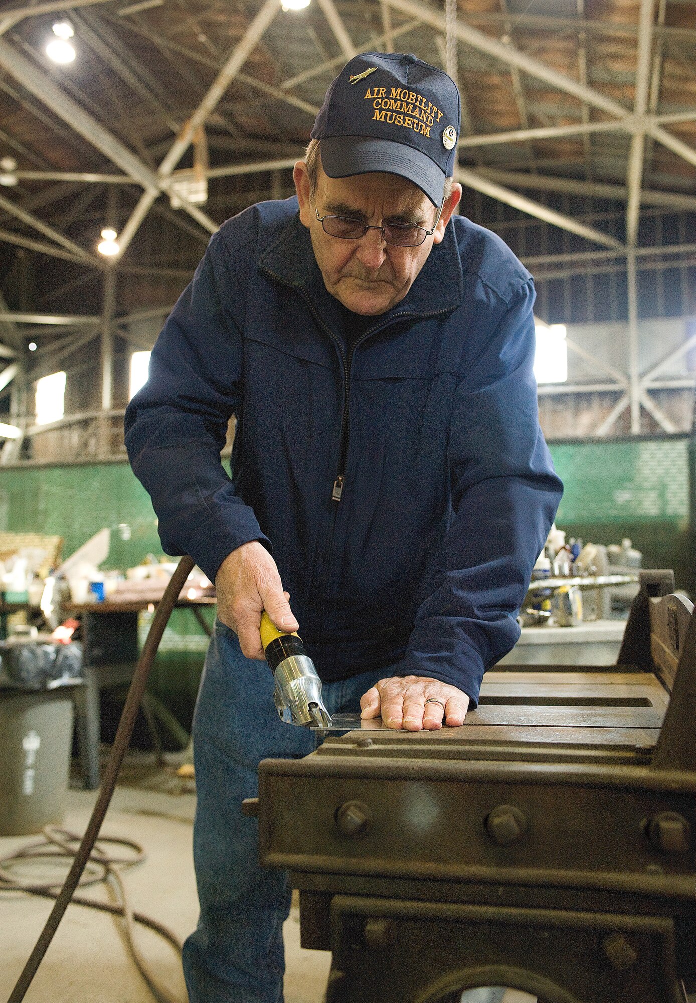 Aaron Fisher, an Air Mobility Command Museum volunteer, cuts sheet metal to repair of an A-26 Invader aircraft.   Mr. Fisher is part of a group of volunteers who repair aircraft for display at the AMC Museum.  (U.S. Air Force photo/Jason Minto)
