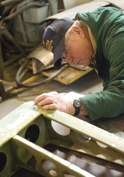 Gene Williams, Air Mobility Command Museum volunteer, covers an A-26 Invader wing with sheet metal so birds won?t nest inside while the plane is on display.  Mr. Williams is part of a group of volunteers who repair aircraft for display at the AMC Museum.  (U.S. Air Force photo/Jason Minto)