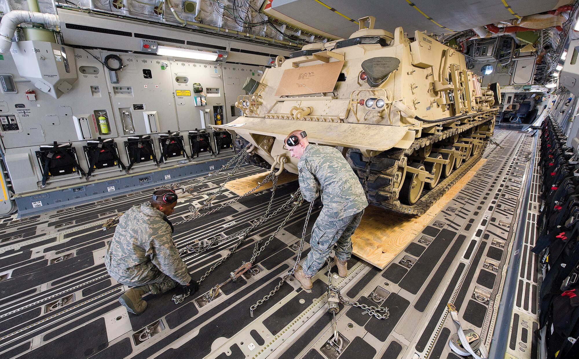 (Left) Airman 1st Class John Ntwiga and Senior Airman Nickolas Castonguay, 436th Aerial Port Squadron, chain down an updated M88A2 HERCULES Tank Retriever to the cargo deck of a C-17 Globemaster III.  The HERCULES is used to safely tow and recover inoperative tanks. The M88A2 provides protection against small arms fire, artillery fragments and anti-personnel mines. It is configured with an A-frame boom, three winches and spade. In comparison to the M88A1, its predecessor, the M88A2 boom can lift 40 heavier loads with its 35-ton lift capacity and the main winch has a constant pull capacity of 70 tons.  (U.S. Air Force photo/Jason Minto)