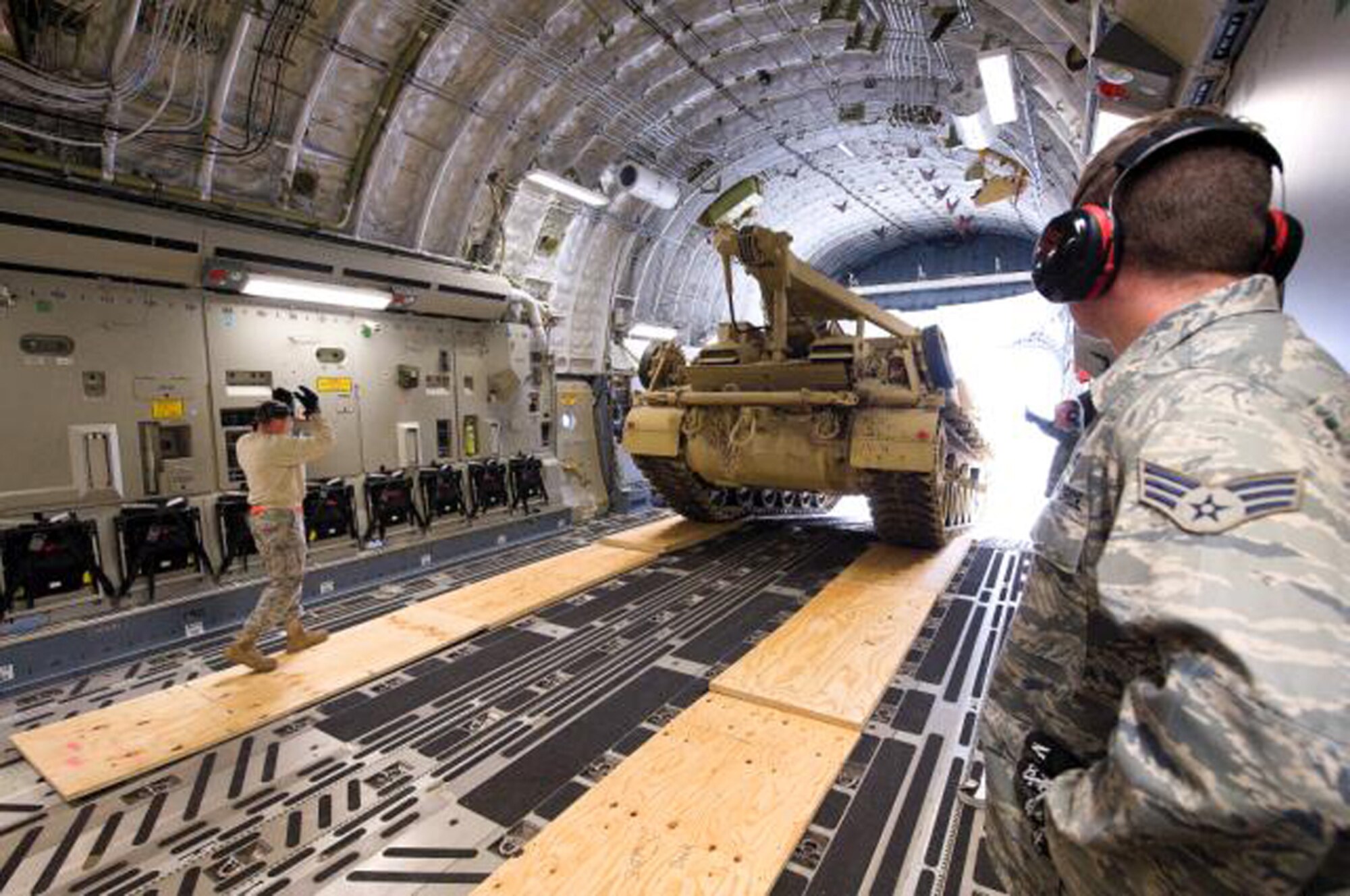(From left) Tech. Sgt. Tony Forcier and Senior Airman Preston Harrell, 436th Aerial Port Squadron, directs the recently updated M88A2 HERCULES Tank Retriever on to a C-17 Globemaster III.  The HERCULES is used to safely tow and recover inoperative tanks. The M88A2 provides protection against small arms fire, artillery fragments and anti-personnel mines. It is configured with an A-frame boom, three winches and spade. In comparison to the M88A1, its predecessor, the M88A2 boom can lift 40 percent heavier loads with its 35-ton lift capacity and the main winch has a constant pull capacity of 70 tons.  (U.S. Air Force photo/Jason Minto)