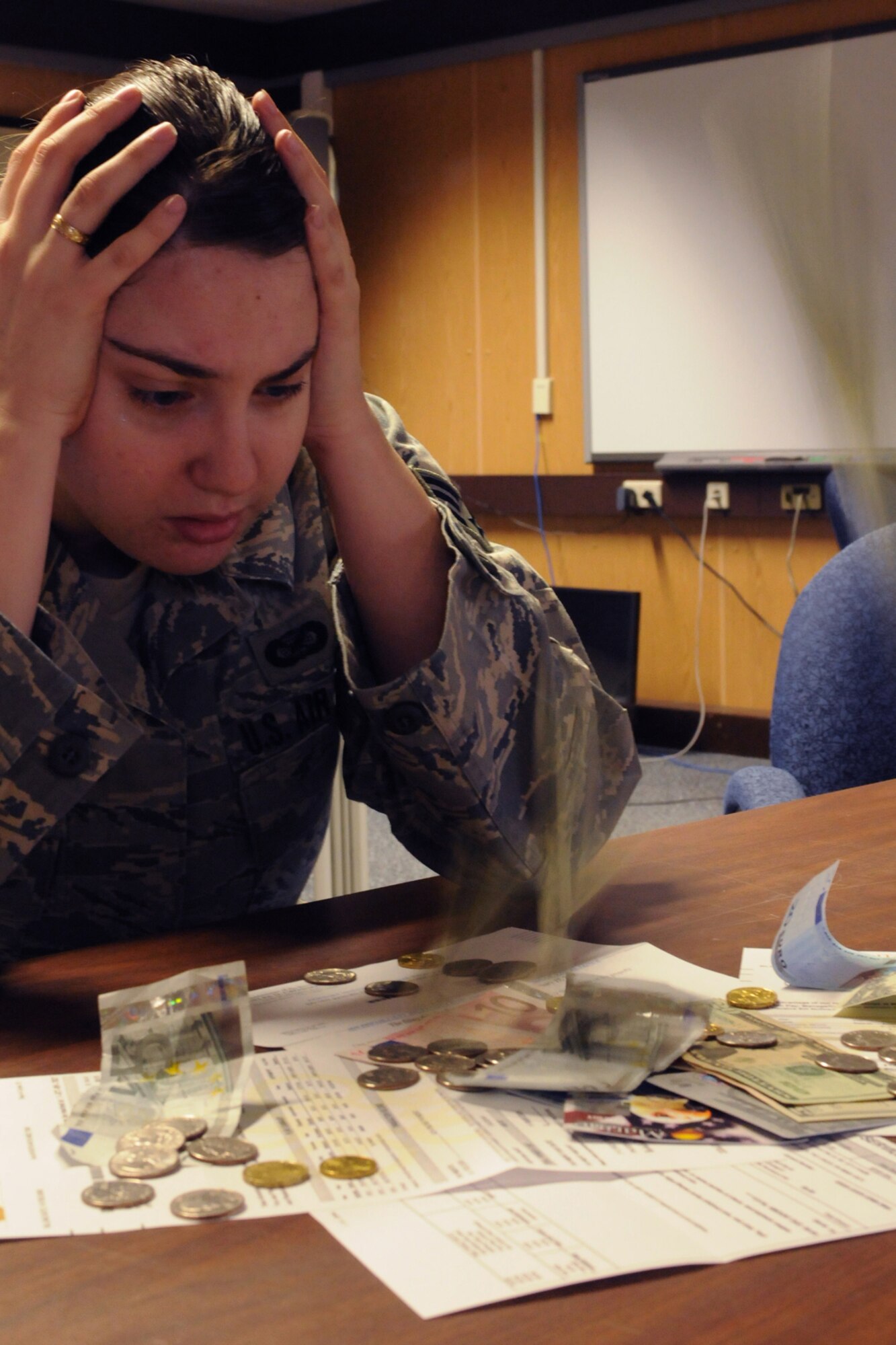 Senior Airman Amanda Dick, 435th Air Base Wing Public Affairs journalist, contemplates how she is going to adjust her current budget due to the upcoming reduction in her cost of living allowance.  Beginning May 1, Airman Dick and other service members currently assigned to Ramstein will see a reduction in their monthly paychecks.  The Overseas COLA is a supplement designed to equalize purchasing power between members overseas and their Continental United States-based counterparts. COLA rates are being reduced worldwide following a study that identified the purchasing power gap has reduced because the prices of goods and services have increased at a greater rate in the United States than in Germany.  (U.S. Air Force photo by Tech. Sgt. Sean White)
