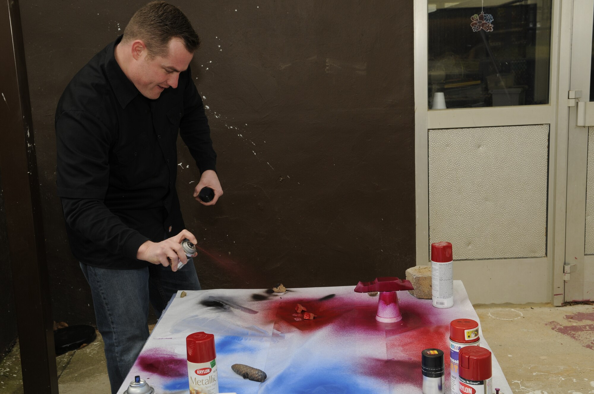 SPANGDAHLEM AIR BASE, Germany -- Staff Sgt. Jonathan Frost, 52nd Civil Engineering Squadron, spray paints parts of his daughter’s Pinewood Derby car March 7, 2009.  The Pinewood Derby will be held March 21, 2009.  (U.S. Air Force photo by Senior Airman Allen Pollard)