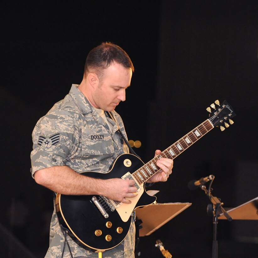 Staff  Sgt. Lonnie Dooley plays guitar for the AFCENT Band Sirocco, as they perform for servicemembers, March 9, 2009, in an undisclosed location in Southwest Asia.  Sergeant Dooley and fellow band members travel throughout the U.S. Central Command's area of responsibility performing for deployed servicemembers.  Sergeant Dooley is native to Graham, Texas, and is deployed from Sembach Air Base, Germany in support of Operations Iraqi and Enduring Freedom and Combined Joint Task Force - Horn of Africa.  (U.S. Air Force Photo by Staff Sgt. Joshua Garcia/released)  	