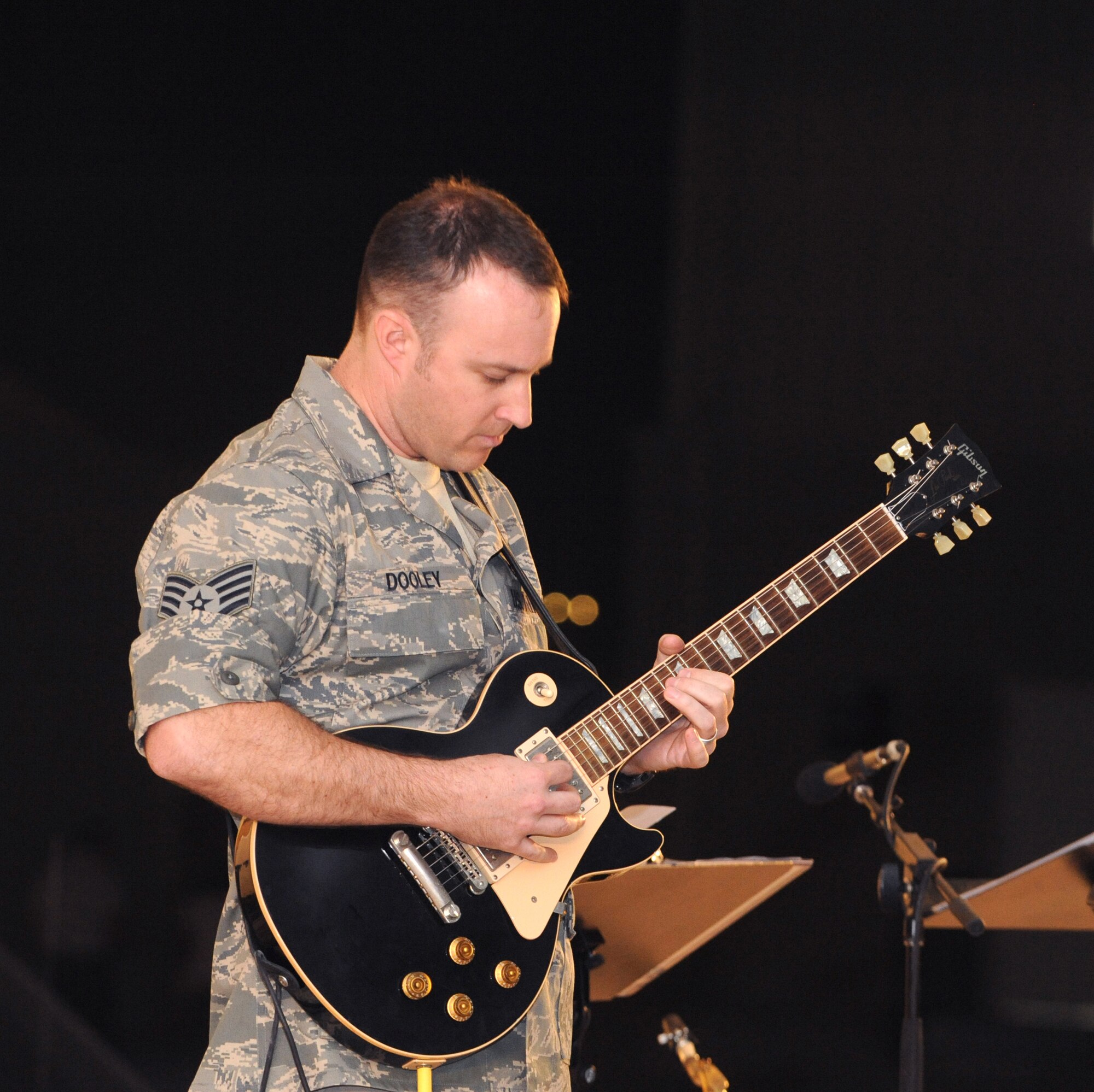 Staff  Sgt. Lonnie Dooley plays guitar for the AFCENT Band Sirocco, as they perform for servicemembers, March 9, 2009, in an undisclosed location in Southwest Asia.  Sergeant Dooley and fellow band members travel throughout the U.S. Central Command's area of responsibility performing for deployed servicemembers.  Sergeant Dooley is native to Graham, Texas, and is deployed from Sembach Air Base, Germany in support of Operations Iraqi and Enduring Freedom and Combined Joint Task Force - Horn of Africa.  (U.S. Air Force Photo by Staff Sgt. Joshua Garcia/released)  	