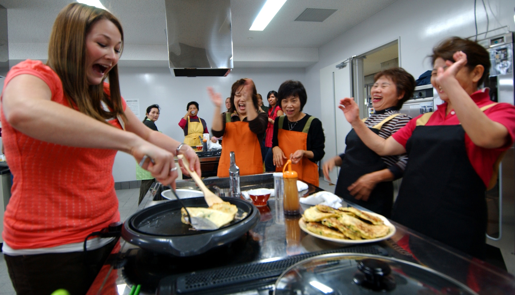 Krystal Roebuck, chairman of the Okinawa Enlisted Spouse Club, learns how to make Okunomiyaki, a Japanese-style pancake, during the U.S.-Japan Sports and Cultural Exchange at the Rotary Plaza in Okinawa, Japan, March 14.  (U.S. Air Force photo/Tech. Sgt. Rey Ramon)
                              