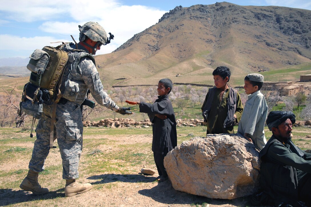 U.S. Army Spc. Jackie Greenlee teaches a boy how to give a high-five 
while on a humanitarian aid mission near Forward Operating Base Lane in Zabul province, Afghanistan, March 11, 2009. Greenlee, a medic, is assigned to Company B, 1st Battalion, 4th Infantry Regiment.