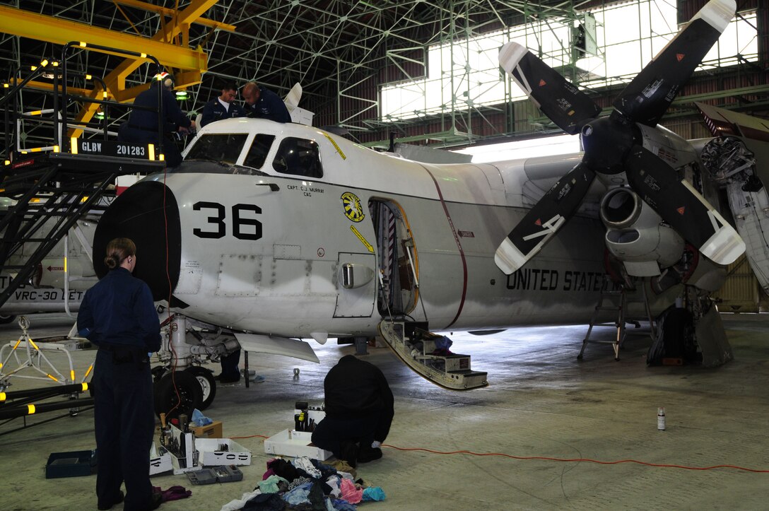 U.S. Navy Sailors from Fleet Logistics Support Squadron 30, Detachment Four perform maintenance on a C-2 Greyhound while aboard Marine Corps Air Station Iwakuni, March 12. After a short 10-day stay here the visiting detachment is now afloat with the USS John C. Stennis as the carrier strike group moves to its next area of operation.