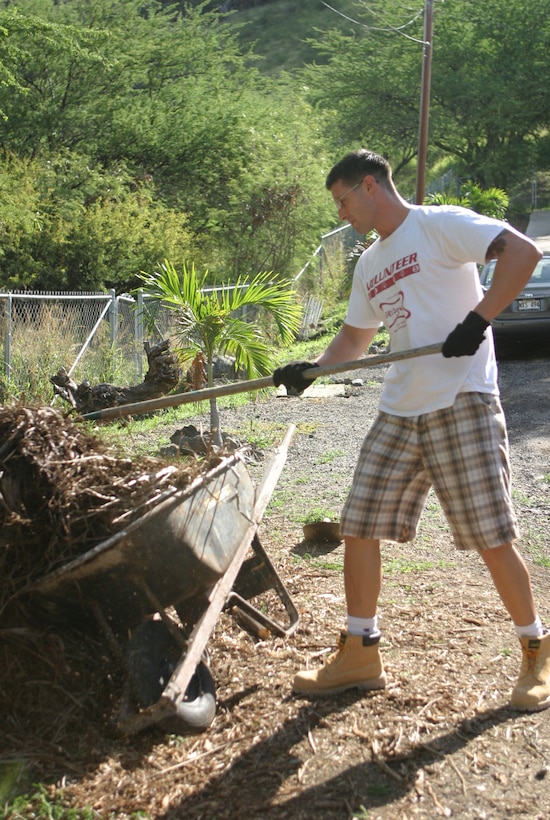 Sgt. Joshua Hamra gathers piles of moss to lay in dogs' living areas at Friends for Life, an animal rescue shelter here March 13. Hamra adopted one of the dogs he saw at the shelter.