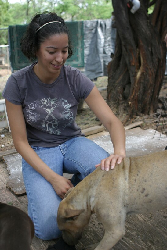 Sgt. Laydilin Carrion plays with a dog at Friends for Life, an animal rescue shelter here, March 13. The shelter rescues animals, restores them to health and prepares them for adoption.