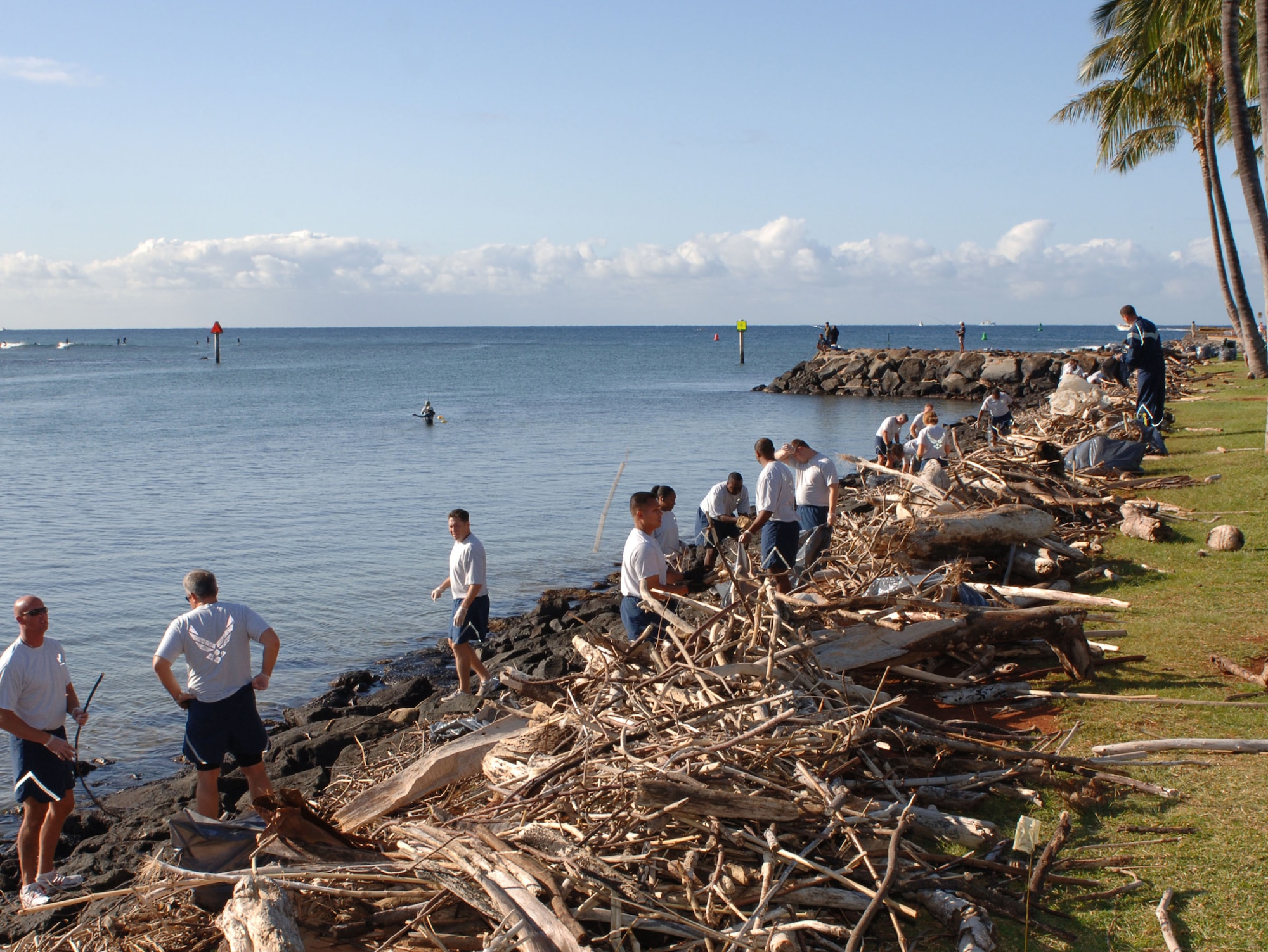 Airmen from 13th Air Force at Hickam Air Force Base, Hawaii, clean trash and debris from the rocky shoreline along Ala Moana Beach Park in Honolulu on March 13.  The Airmen volunteered for the beach clean-up as part of 13th Air Force's Jungle Day, a tradition for the unit that occurs every Friday the 13th. (U.S. Air Force photo/Oscar A. Hernandez)
