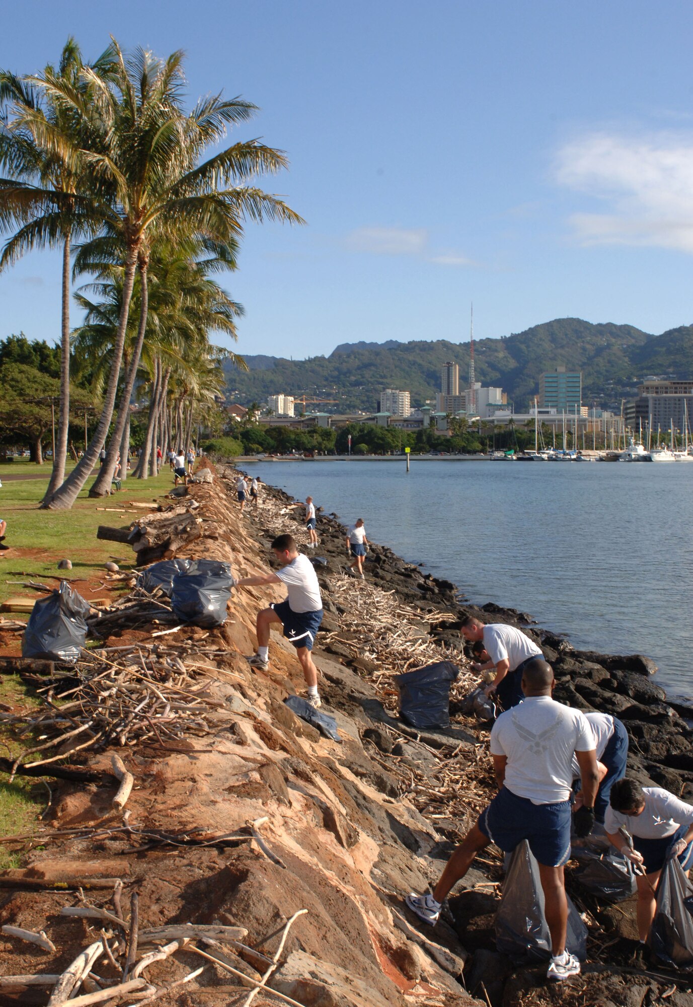 Airmen from 13th Air Force at Hickam Air Force Base, Hawaii, clean trash and debris from the rocky shoreline along Ala Moana Beach Park in Honolulu on March 13.  The Airmen volunteered for the beach clean-up as part of 13th Air Force's Jungle Day, a tradition for the unit that occurs every Friday the 13th. (U.S. Air Force photo/Oscar A. Hernandez)