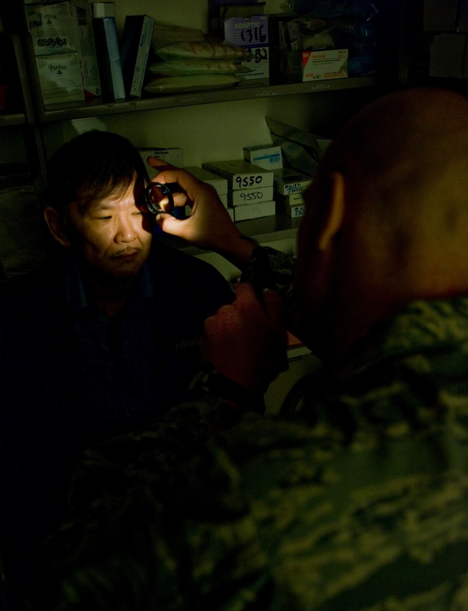 Capt. Justin Sandholmes, an optometrist at MacDill Air Force Base, examines a patient's cornea for abnormalities at a health clinic in Kwethluk, Alaska, on March 10, 2009.  A joint military medical team is deployed to Kwethluk, a small village in Western Alaska, in support of Operation Arctic Care. This year's Navy-led mission has teams in 11 villages in Alaska's Yukon-Kuskokwim Delta region providing medical, dental and veterinary support at no cost to Alaskan natives. (U.S. Air Force photo by Senior Airman Christopher Griffin)