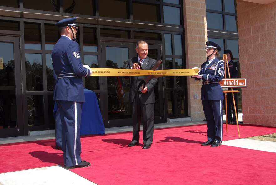 Retired Air Force Maj. Gen. Philip Killey cuts the ribbon to the new 1st Air Force complex during a dedication ceremony March 13.  The facility, the Killey Center for Homeland Operations, was named in honor of the general.  General Killey was the first Air National Guard general to lead an Air Combat Command Numbered Air Force organization in a federal mission from 1994 to 1998. In addition, 1st AF honored retired Air Force Maj. Gen. Larry Arnold by naming the access road to the facility L.K. Arnold Way. (U.S. Air Force photo by Lisa Norman)