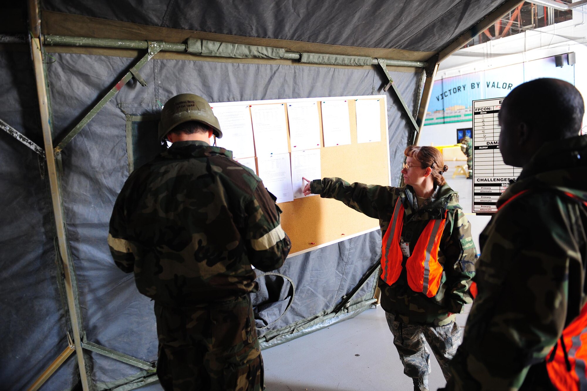 SHAW AIR FORCE BASE, S.C. -- Two transition area personnel brief an Airman coming on-shift during the exercise on the latest battle staff directives Feb 24. The directives give Airmen instructions on actions they must take prior to and during participation in the exercise. (U.S. Air Force photo/Staff Sgt. Henry Hoegen)