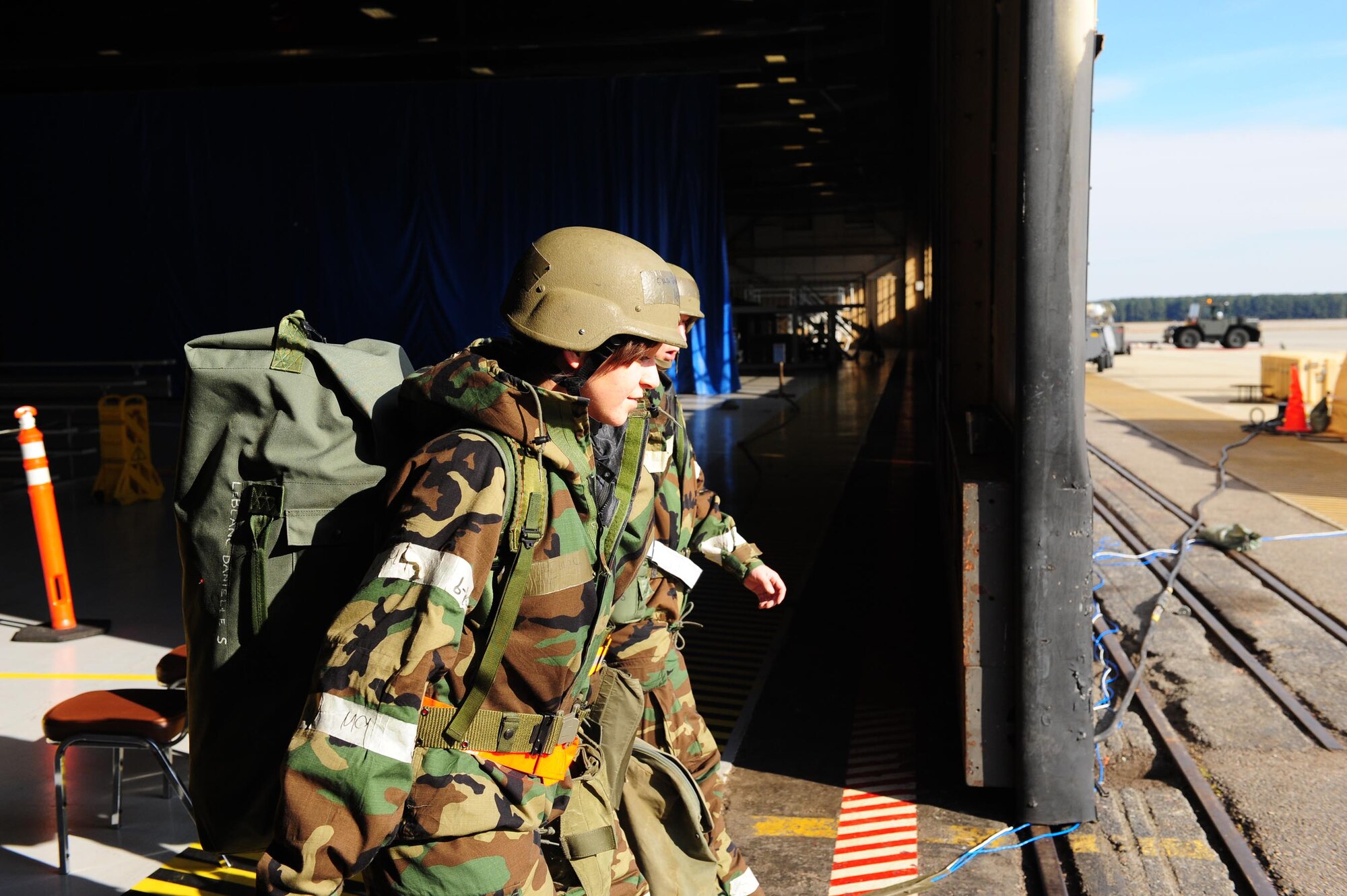 SHAW AIR FORCE BASE, S.C. -- Two exercise participants leave Hangar 1200 to join the war. Once they leave the transition area, they are subject to all scenarios and must perform accordingly. (U.S. Air Force photo/Staff Sgt. Henry Hoegen)