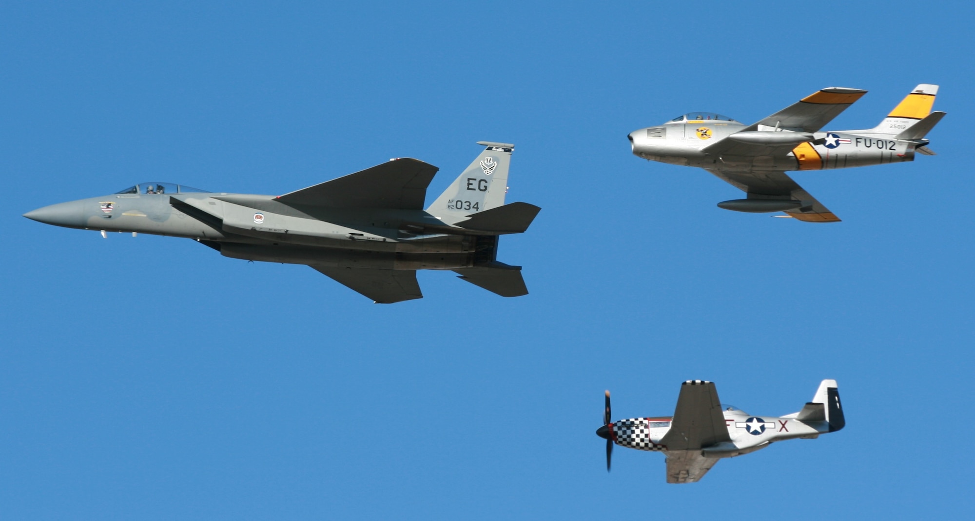 Capt. Sam Joplin flies the West Coast Demonstration team’s F-15 Eagle in a three-ship heritage formation over ‘show center’ with a TF-51 Mustang and an F-86 Sabre. (U.S. Air Force photo/Master Sgt. Bryan Jones) 