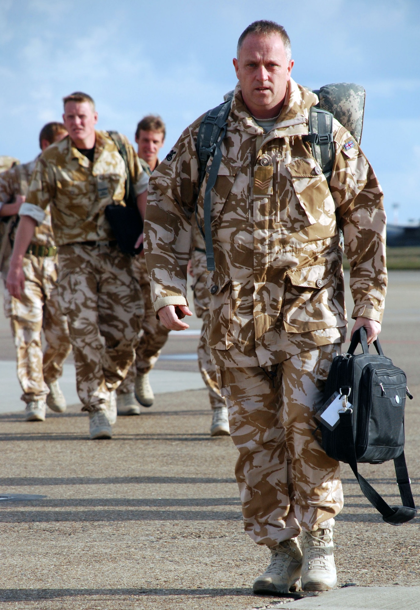 Royal Air Force Sergeant Ady Shaw carries his deployment gear from a military charter plane to the customs area at RAF Mildenhall, England, March 4 after a six-month deployment to Kandahar Air Base, Afghanistan. About 150 RAF servicemembers landed at RAF Mildenhall instead of their typical point of return, shaving about five hours off their journey home to RAF Honington. (U.S. Air Force photo/Staff Sgt. Austin M. May) 
