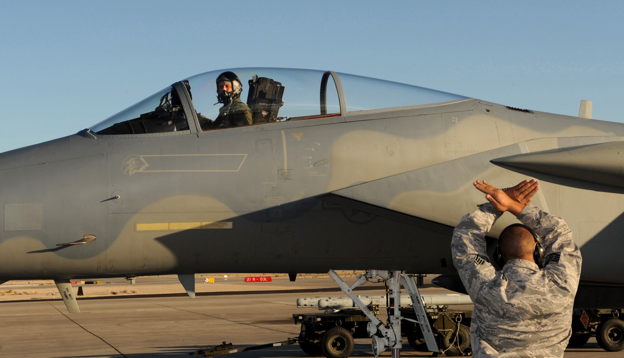 NELLIS AIR FORCE BASE, Nev. -- Staff Sgt. Malik Coleman, 390th Aircraft Maintenance Unit dedicated crew chief, guides 366th Fighter Wing Commander Col. John D. Bird II as he parks his aircraft at Nellis Air Force Base on March 4. Colonel Bird came to Nellis to participate in the U.S. Air Force Weapons School. Comprised of 16 squadrons, the weapons school teaches graduate-level instructor courses that provide the world's most advanced training in weapons and tactics employment to officers of the combat air forces. (U.S. Air Force photo/ Airman 1st Class Debbie Lockhart)