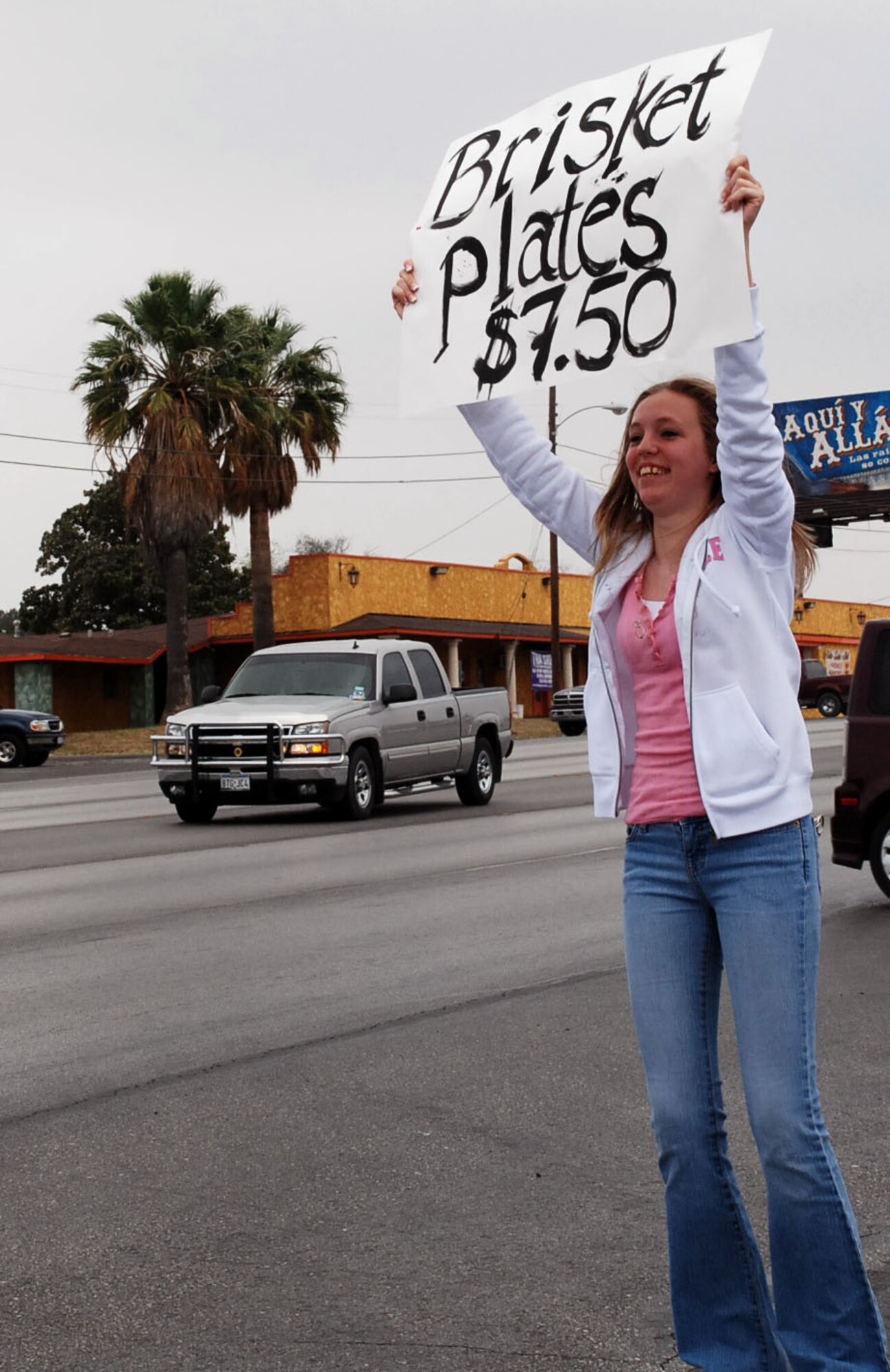 LAUGHLIN AIR FORCE BASE, Texas – Airman 1st Class Jessica Halimton, 47th aerospace physiology unit and fundraiser volunteer, holds up sign on Veterans Ave. in Del Rio to attract more customers to Laughlin’s brisket fundraiser March 7. (U.S. Ai r Force photo by Tech. Sgt. Joel Langton) 