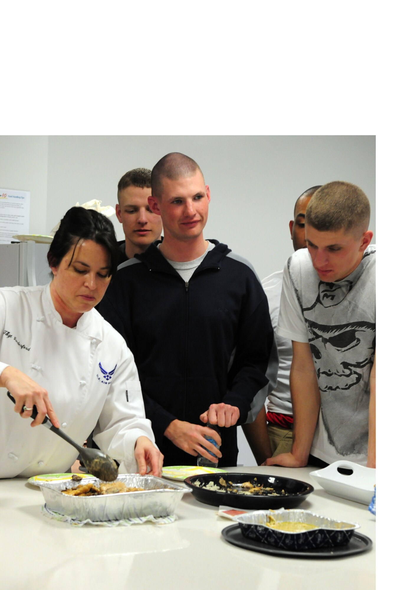 Tech. Sgt. Teresa Vanderford demonstrates cooking techniques for Airmen at the United States Air Force Honor Guard dormitory March 12. The recipes demonstrated included chicken cordon bleu and poached rolled chicken with parsley and tarragon. These classes are held monthly and teach Airmen how to shop, handle and prepare their own meals. “We’re doing this to instruct these young Airmen in the basics of food preparation and menu handling so they have a healthy alternative to fast food,” said Sergeant Vanderford. (U.S. Air Force photo by Airman 1st Class Susan Moreno)