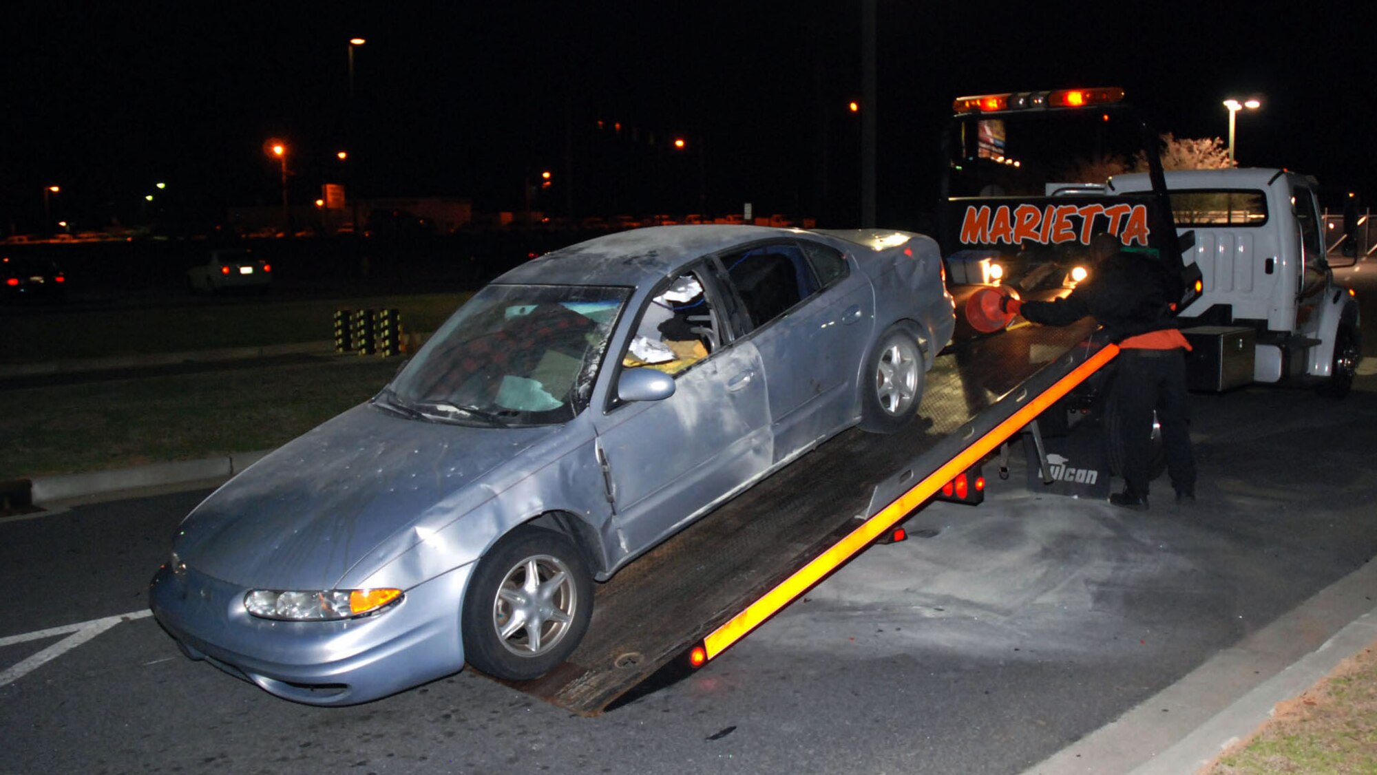 A tow truck removes a car from the main entrance to Dobbins Air Reserve Base, Ga. Authorities received a bomb threat March 11, 2009, after the owner parked the car and claimed it contained a dangerous device. Explosive ordnance disposal specialists from the base used water bottle charges to disrupt the contents of the vehicle so items could be removed and the scene rendered safe. (U.S. Air Force photo/Master Sgt. Stan Coleman)