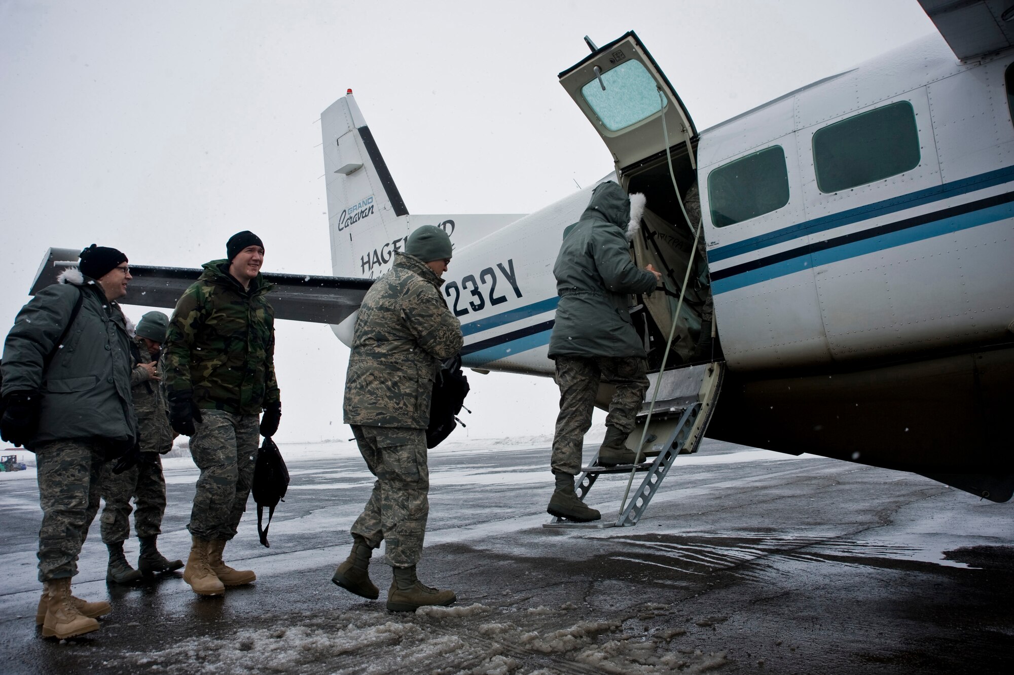 Members of the U.S. Air Force Band of the Pacific's Alaska Brass board a plane in Bethel, Alaska, to travel to a performance in Mountain Village on March 11, 2009. The concert of the five-piece brass and percussion ensemble was part of Operation Arctic Care, a Navy-led medical readiness exercise providing no-cost health care and veterinary support to 12 villages in Western Alaska. (U.S. Air Force photo by Senior Airman Christopher Griffin) 