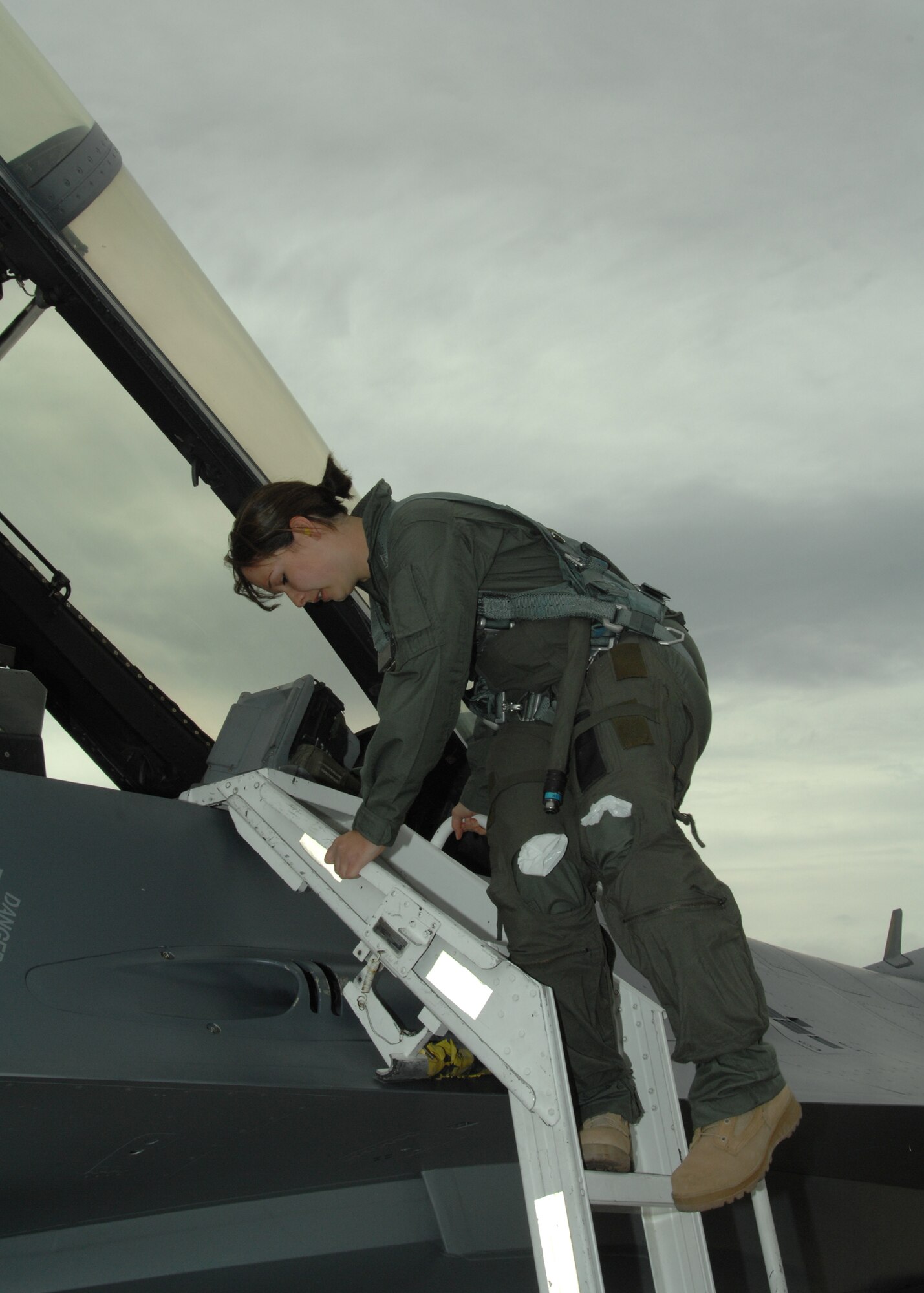 Senior Airman Heather Maldonado of the 355th Equipment Maintenance Squadron here, climbs down a ladder after her incentive flight here March 6 in an F-16 Fighting Falcon -- with both airsickness bags unused and still tucked into her G-suit. Airman Maldonado said the suit "really puts pressure on your stomach...but I didn't get sick." (U.S. Air Force photo/Staff Sgt. Jake Richmond)